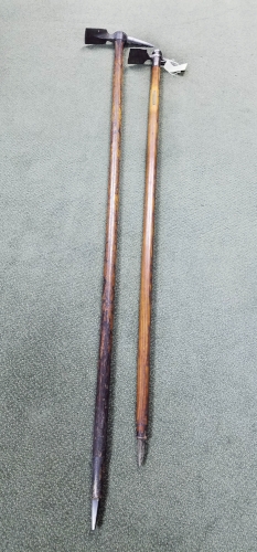  Two alpenstock, full length, with the cutting implement at the top and ice pick at the bottom. 