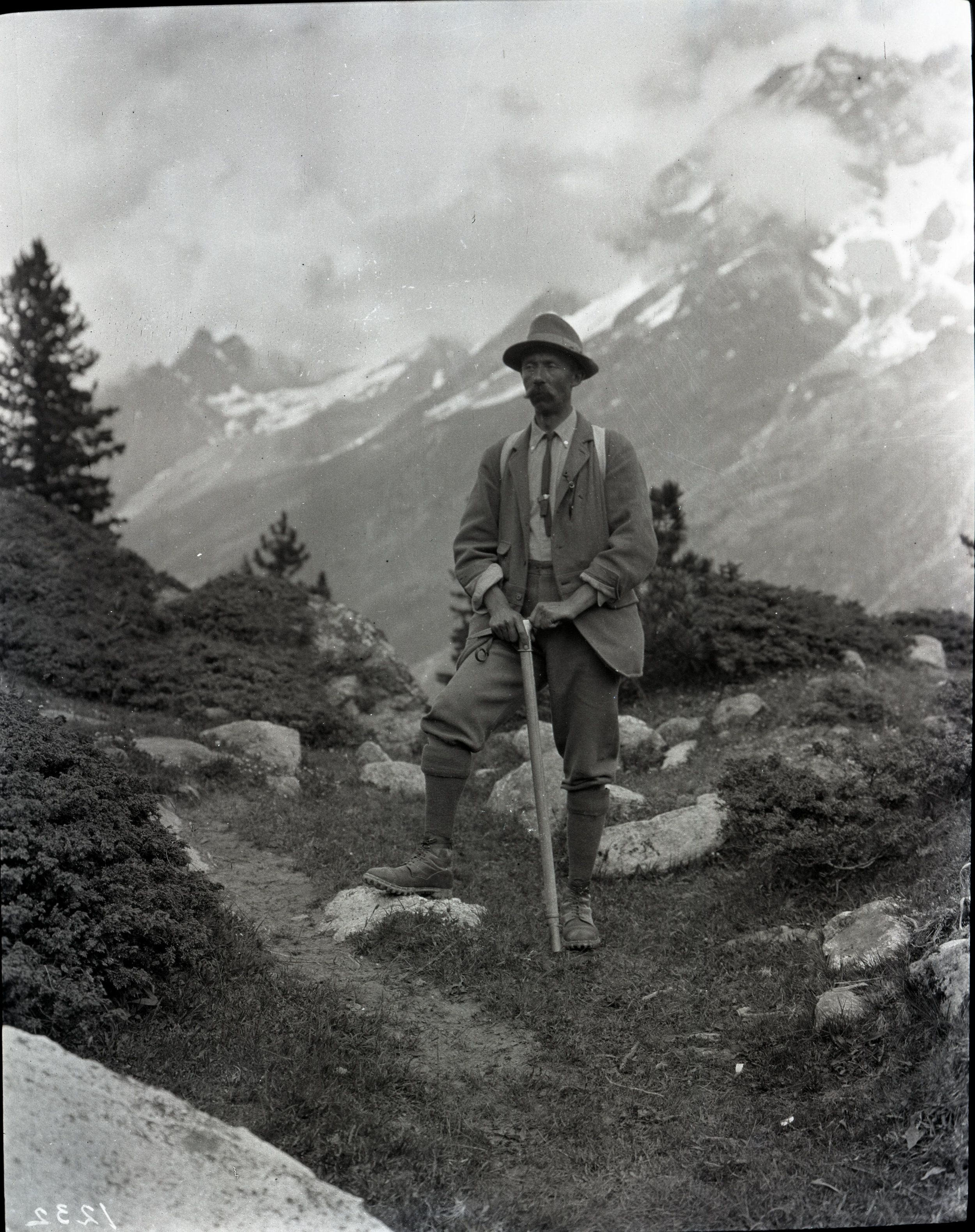  A mountaineer resting his hands on his ice axe while on the trail. From the Andrew James Gilmour collection 