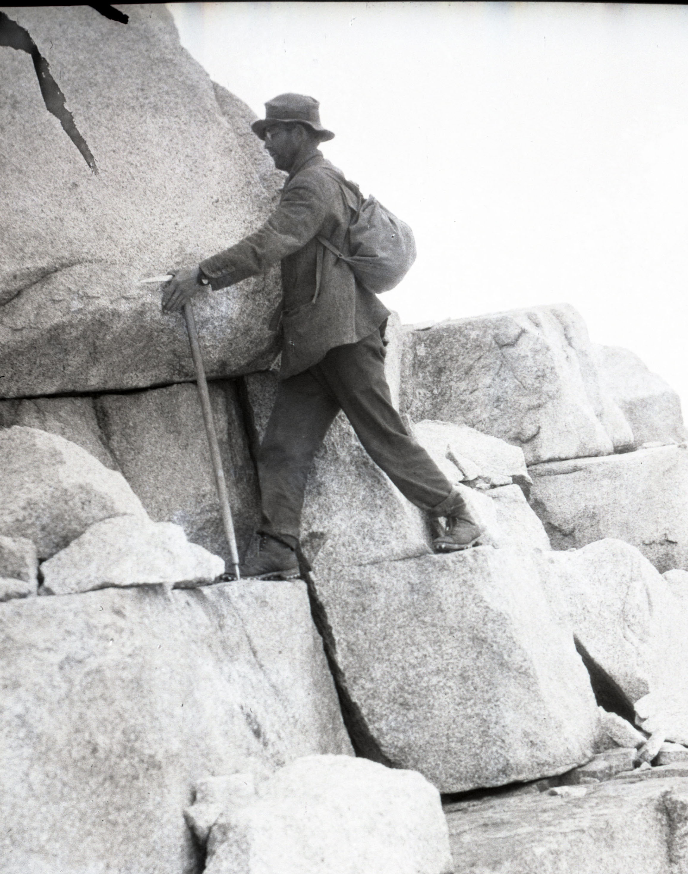  A climber ascending a rock face, using his ice axe as a walking stick. From the collections of the American Alpine Club. 
