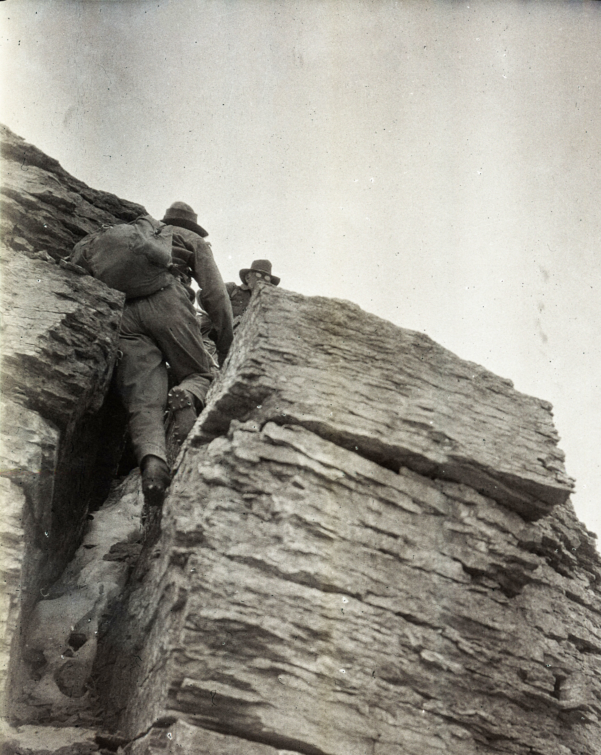 Climbers in a crack near the top of Mumm Peak, Canada