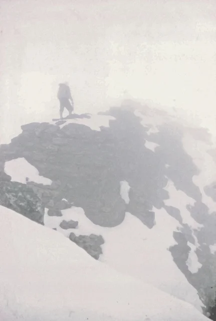 Below Balcony Camp, we found the rocks deeply buried, by not unduly difficult. Visibility was about seventy feet. Once past the sharp snow ridge, we started looking for the ice axe marking our cache.