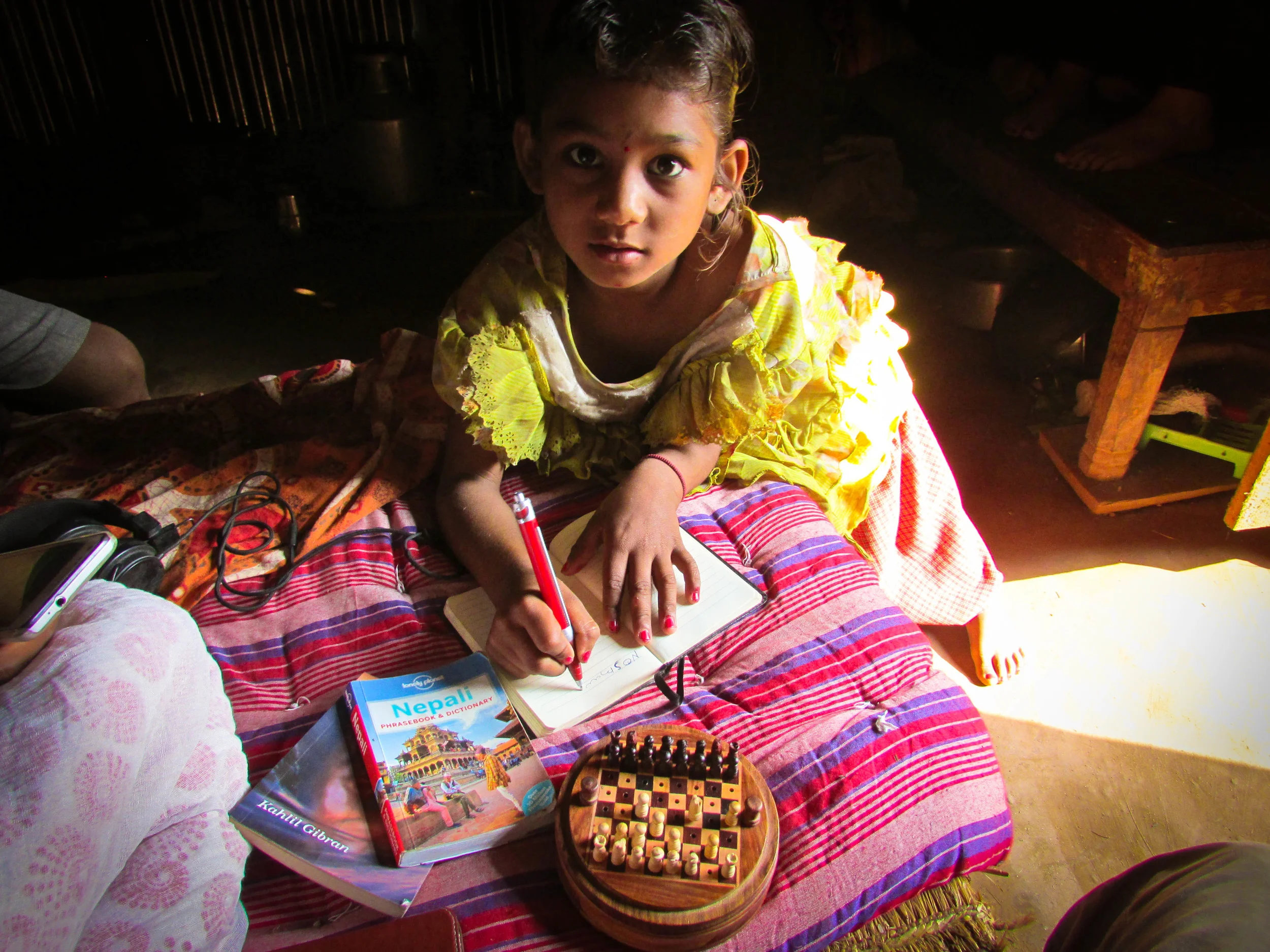 8 year old Nambrita takes notes during a chess lesson in her temporary home in Agara. Her family has been hosting Good Earth and Expansion Nepal members during the preparation and initial building days before the holiday break of Darshain. 