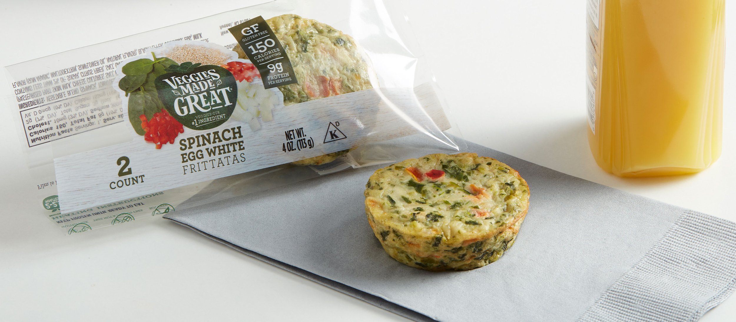 frittata on napkin with open wrapper and orange juice