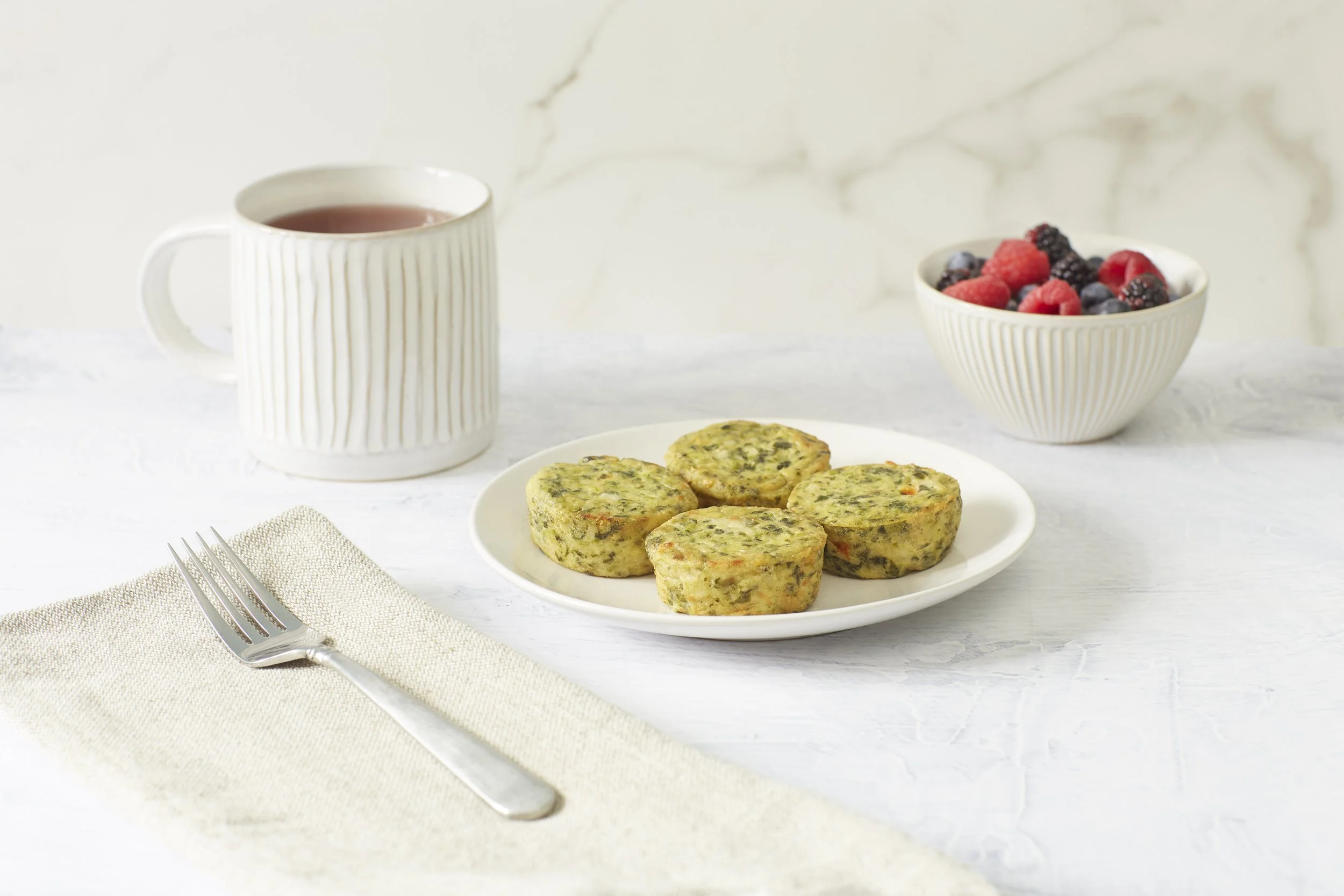 spinach egg white frittatas on plate with coffee and fruit