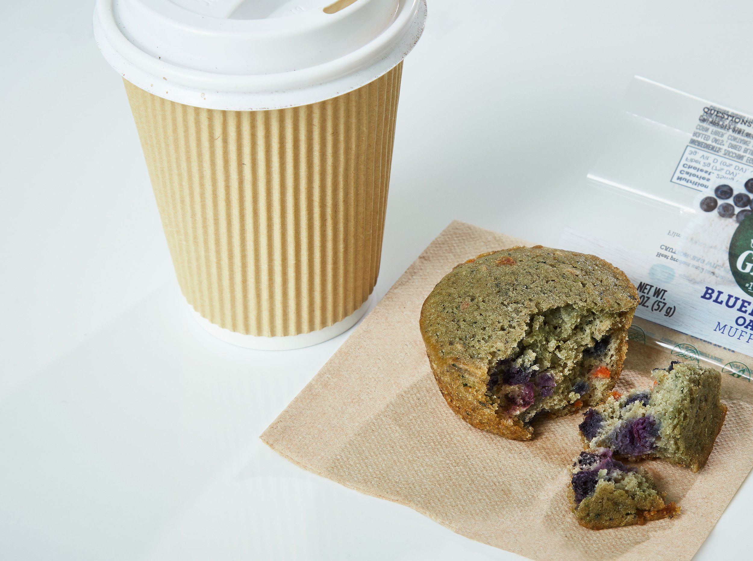 muffin broken open with coffee to-go cup