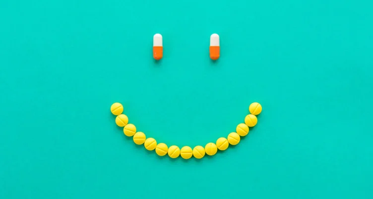 A smiley face made out of supplement capsules.