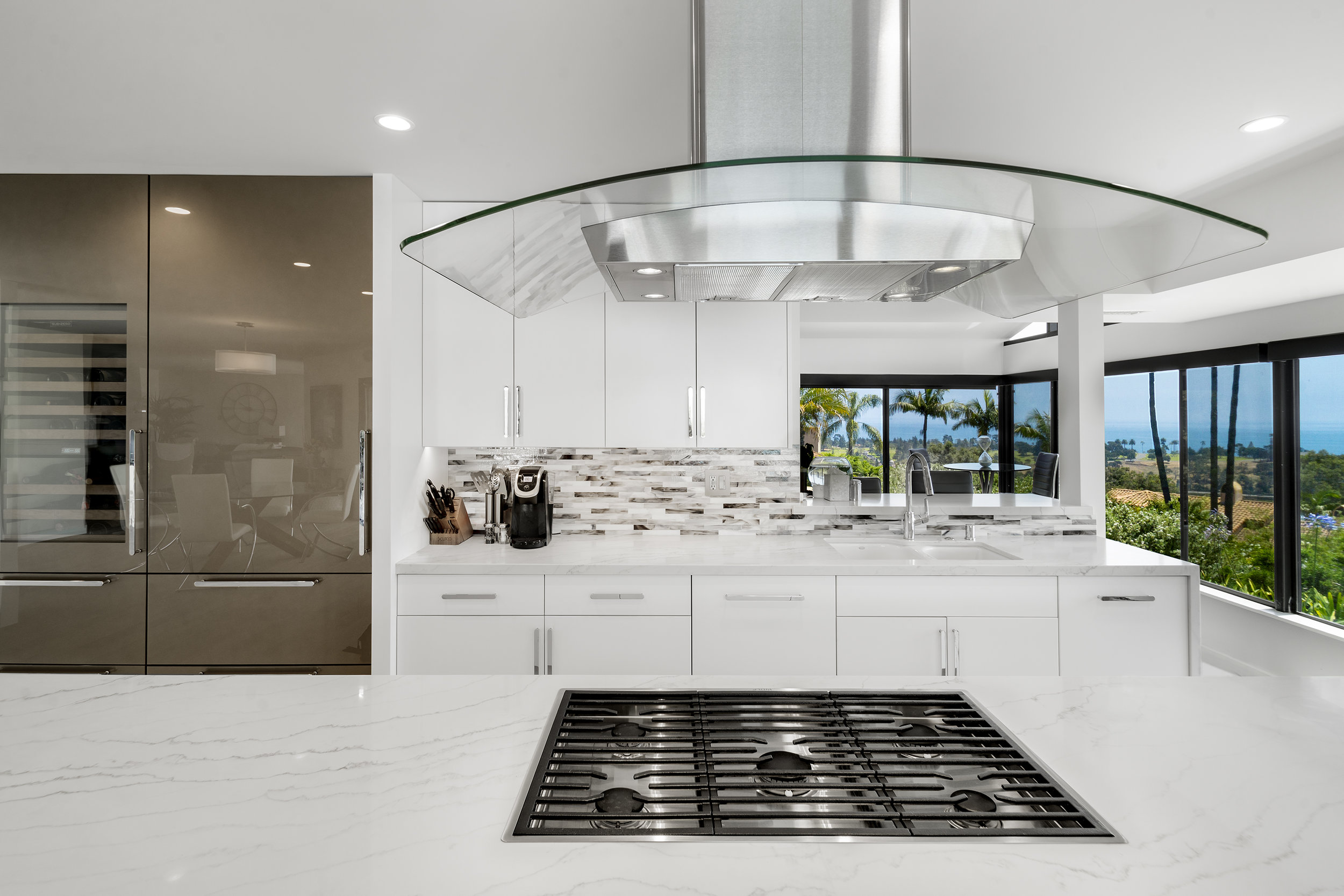 Reflective and bright surfaces add to the clear open feel of the workspace. A pass through to the TV room provides a private but shared space.