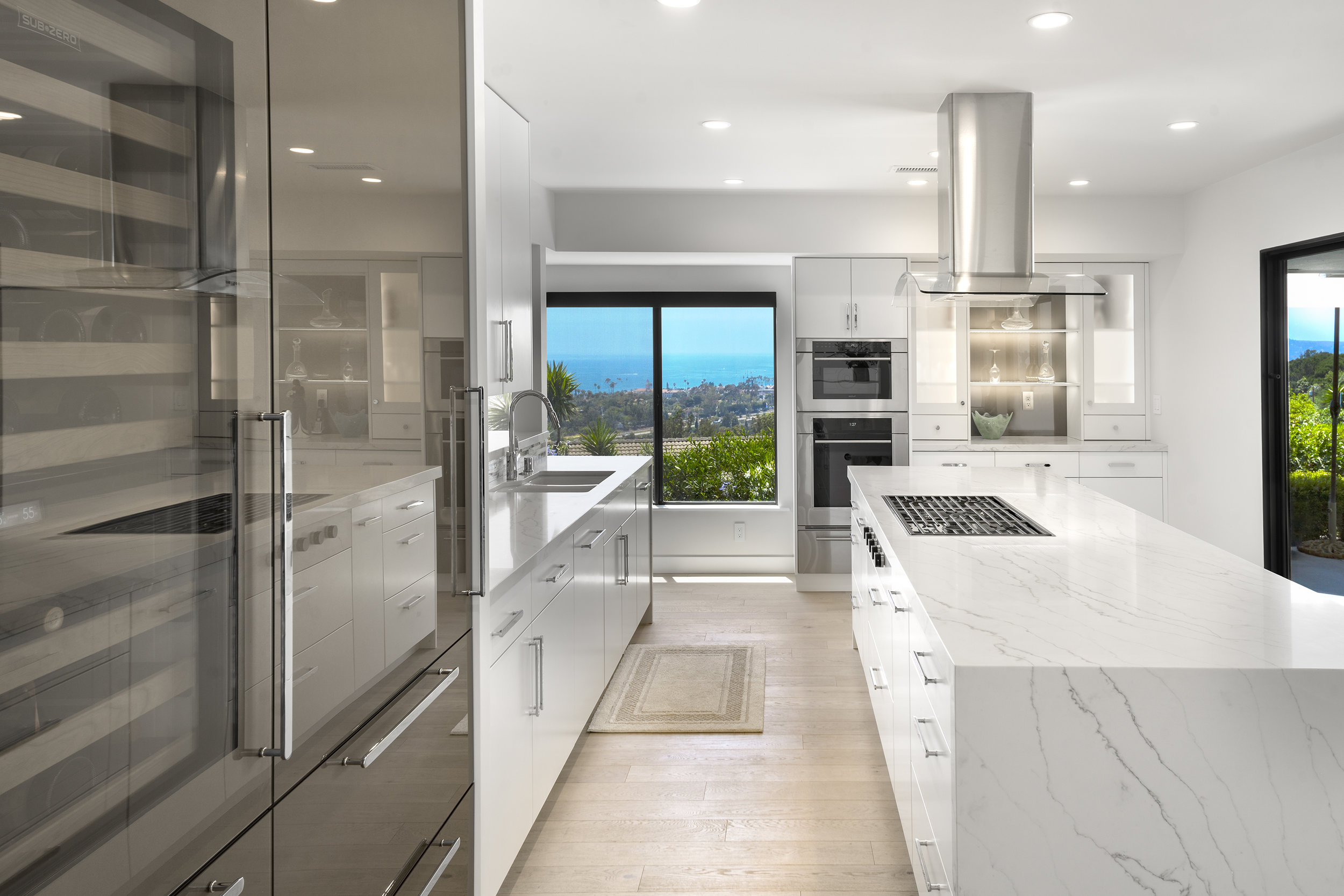 The island provides seating for 6 as well as detailed storage for the chef's collection of cookware. Beautiful views from every angle of the kitchen brings in the California light.