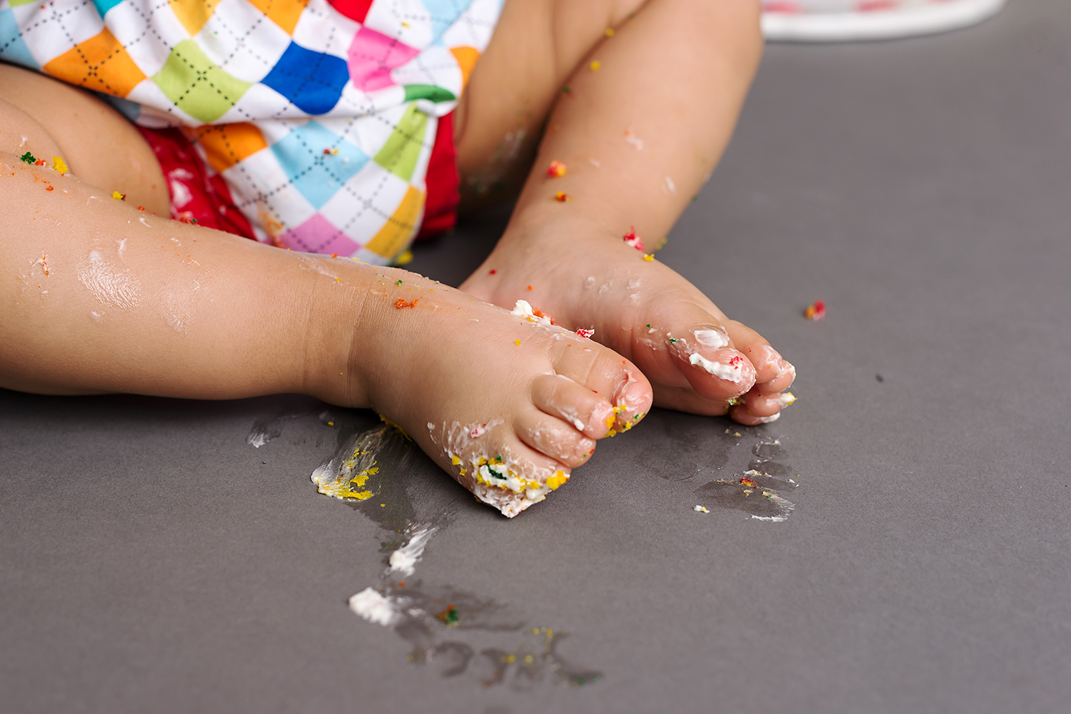 close up of cute baby feet during a cake smash milestone photo shoot