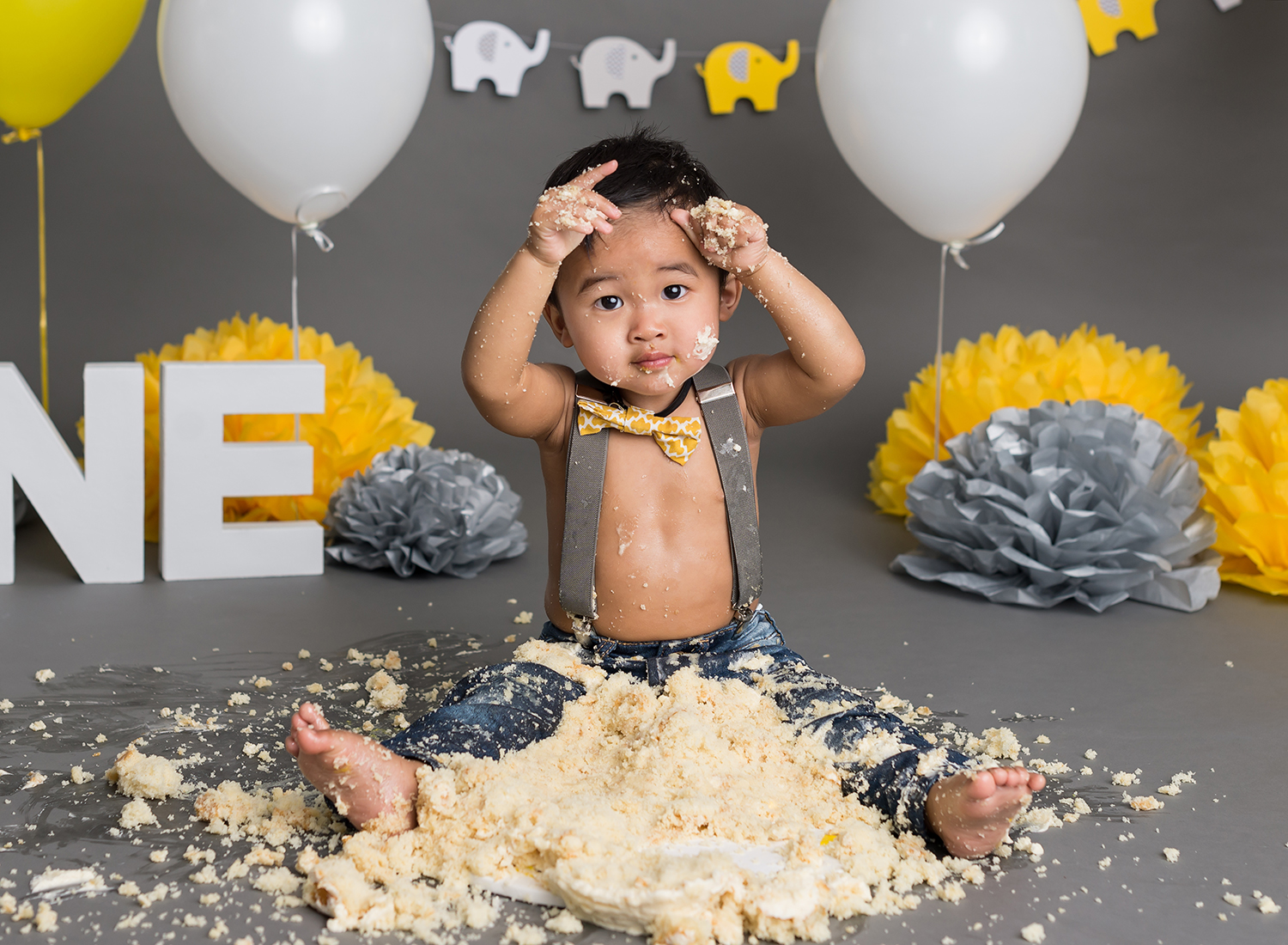 cake smash milestone baby shoot with grey and yellow color elephant theme