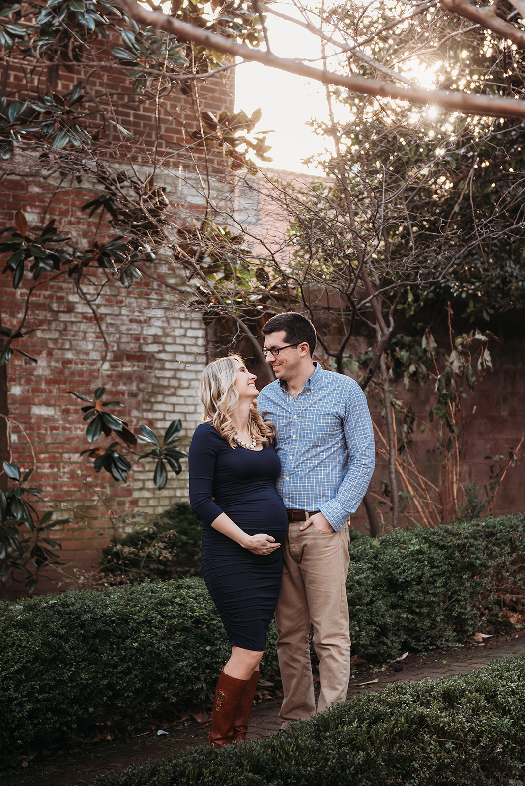 Alexandria VA maternity photo shoot of couple standing in park looking at each other.jpg