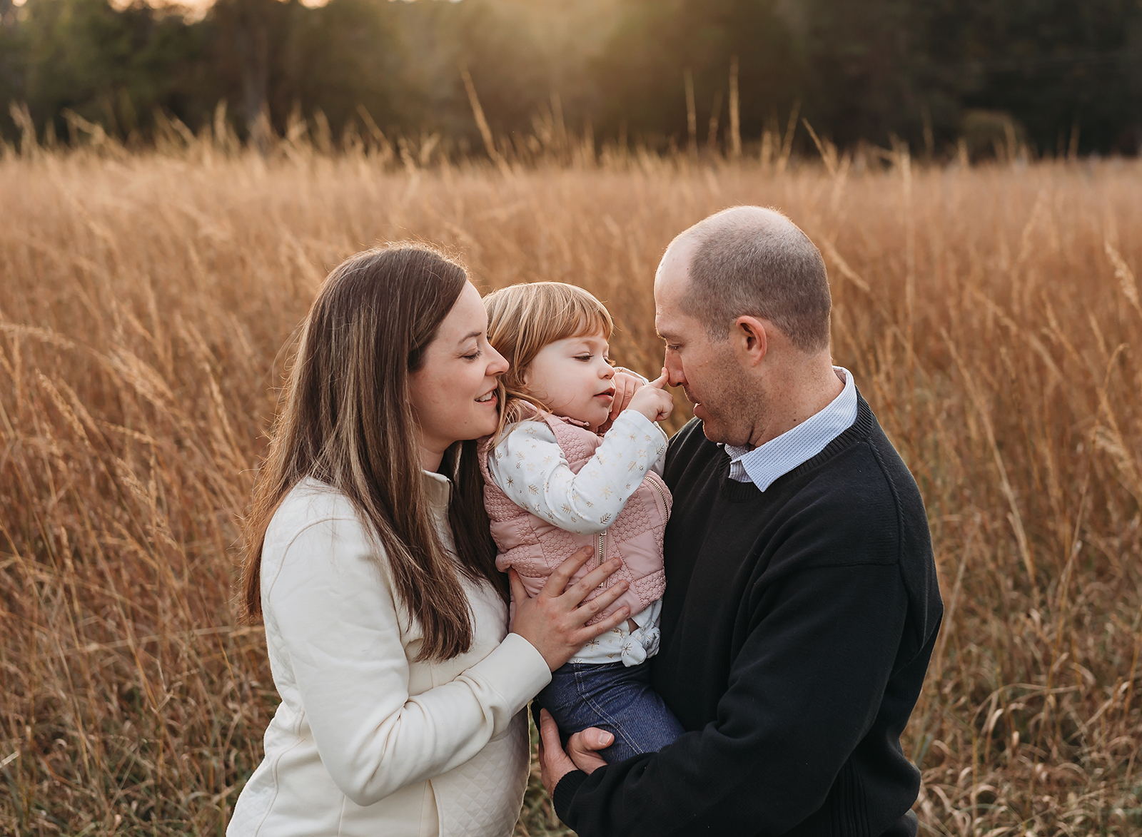 Northern VA family photographer of family having fun in a field