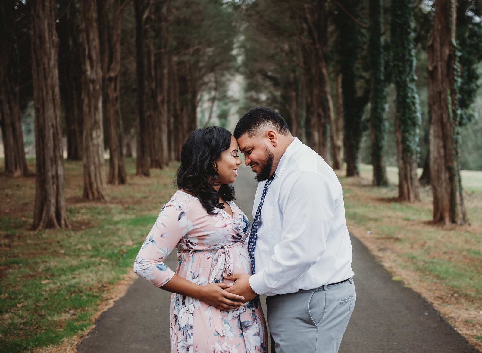 husband and wife holding each other with hands on belly from maternity Warrenton session.jpg