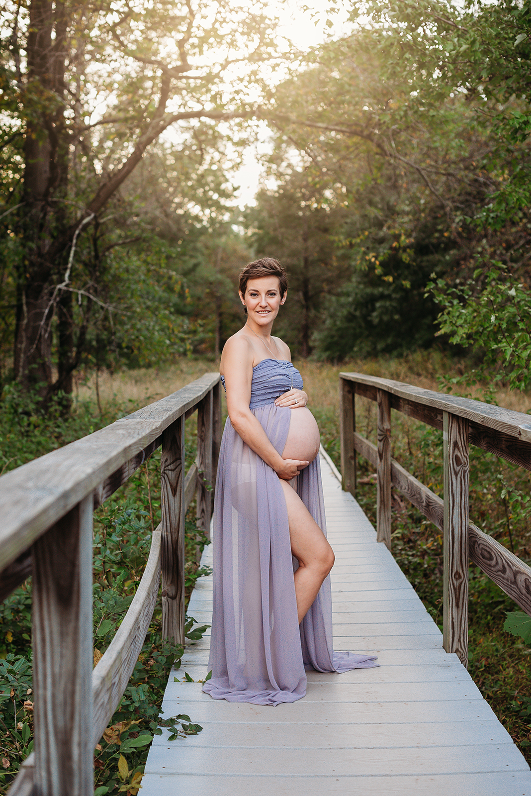 maternity session model in lavender sheer gown standing on bridge.jpg