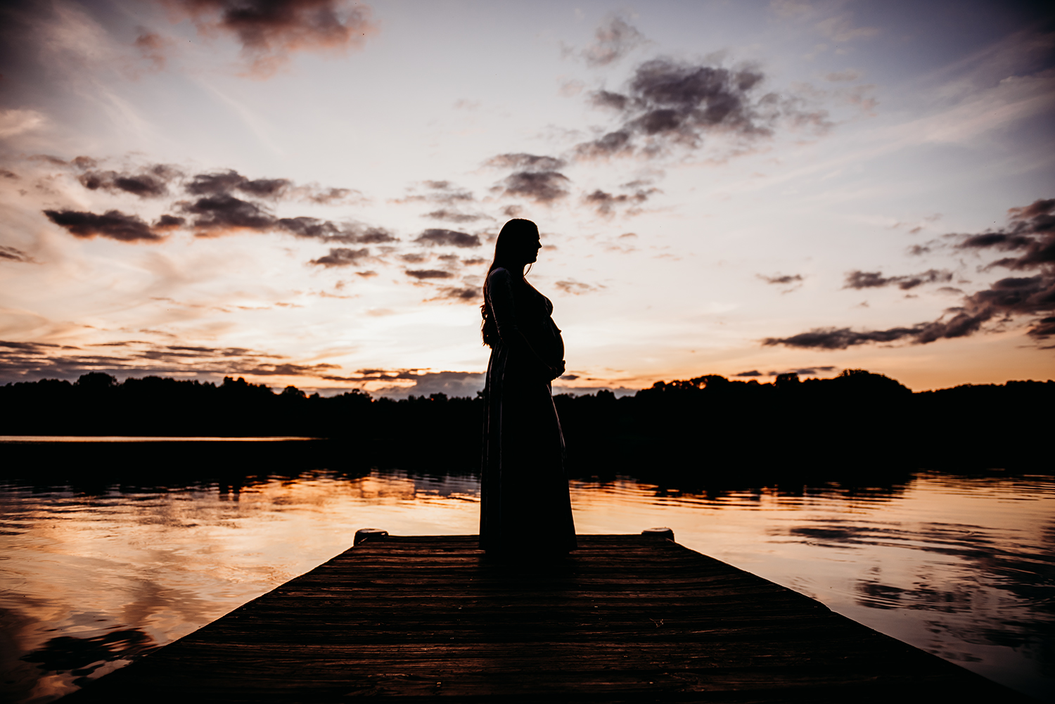 maternity sunset silhouette on dock with water.jpg