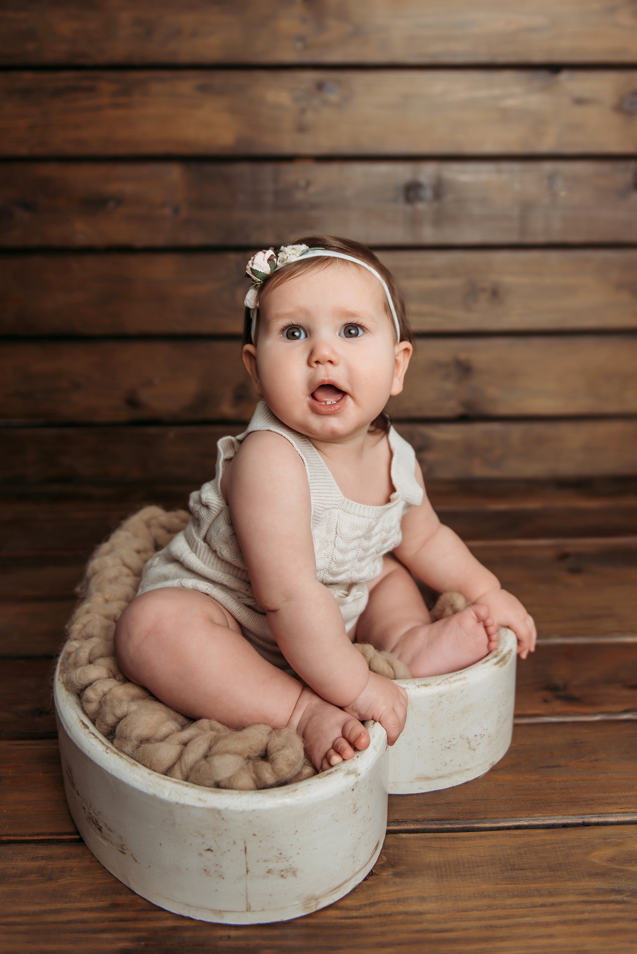 baby girl sitting in heart shaped photography prop.jpg
