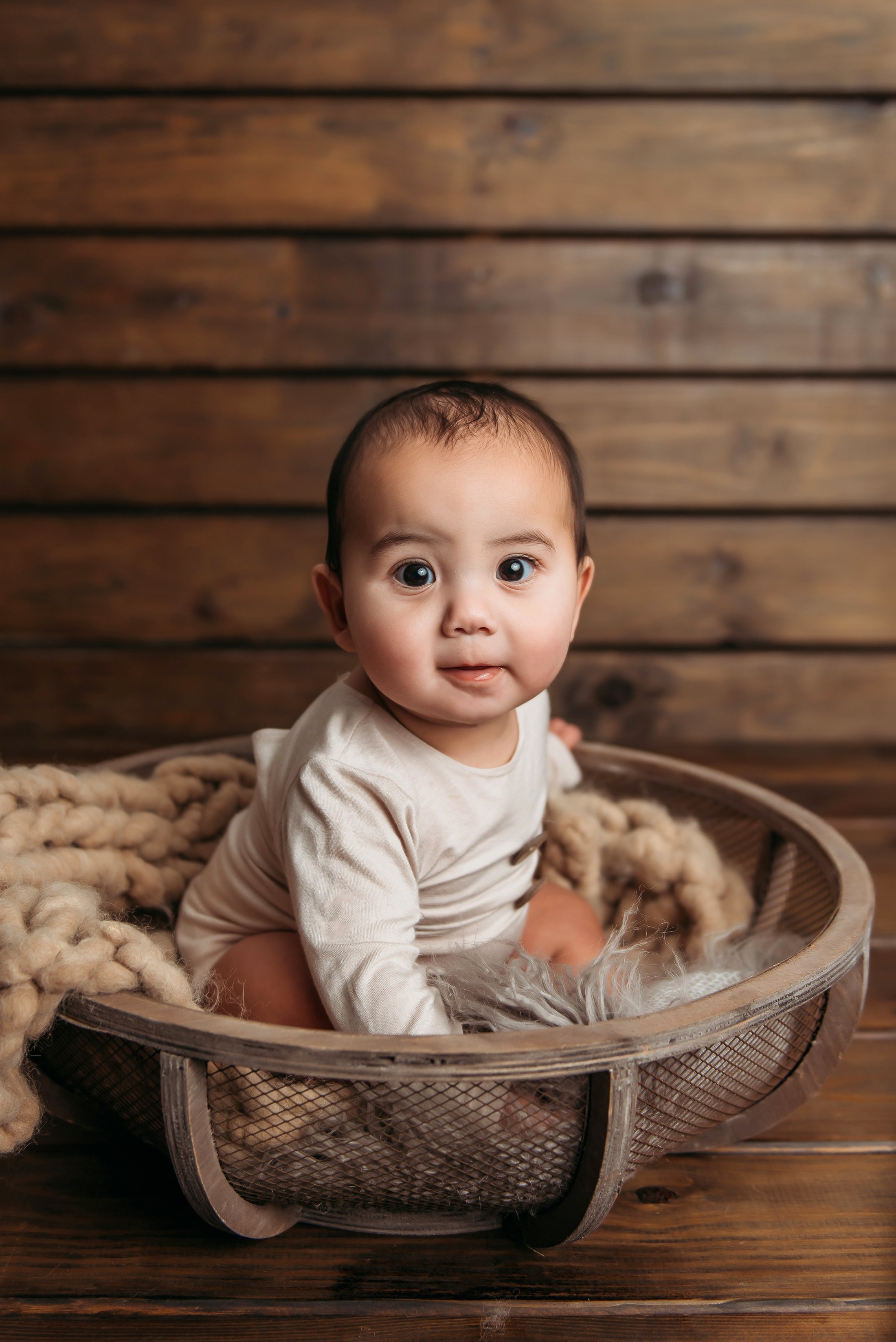 baby boy 6 months sitting in basket smiling.jpg