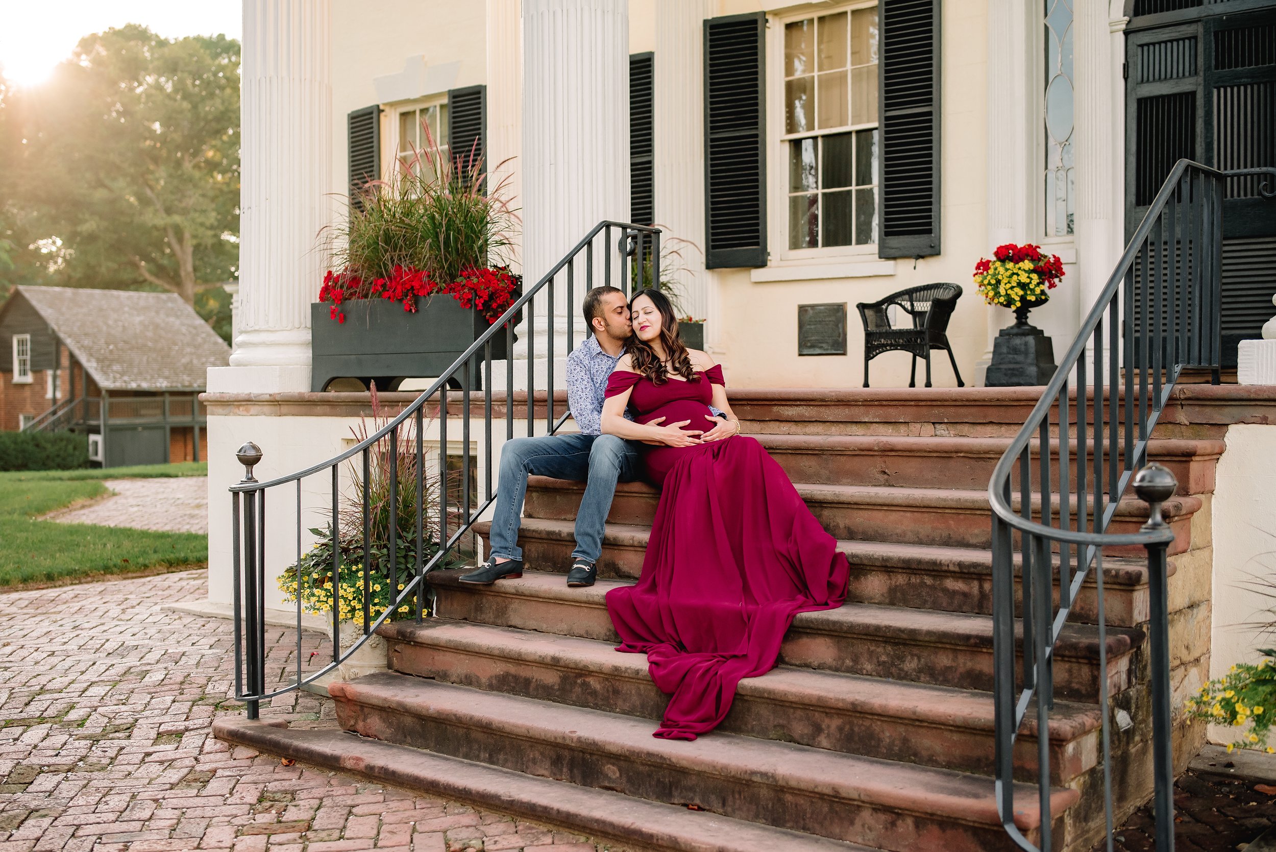 maternity session with woman sitting on stairs in red gown.jpg