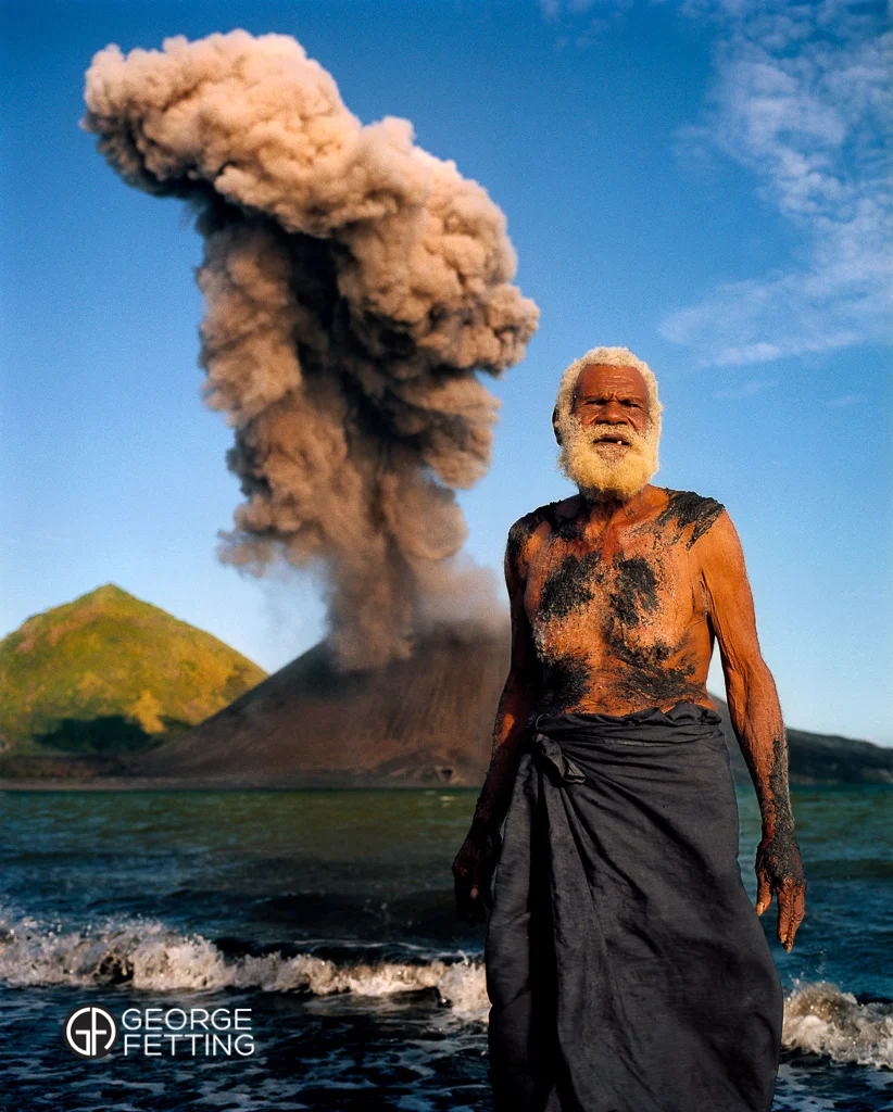 Local elder Ken Kolias and Tavurvur the volcano venting Rabaul PNG.