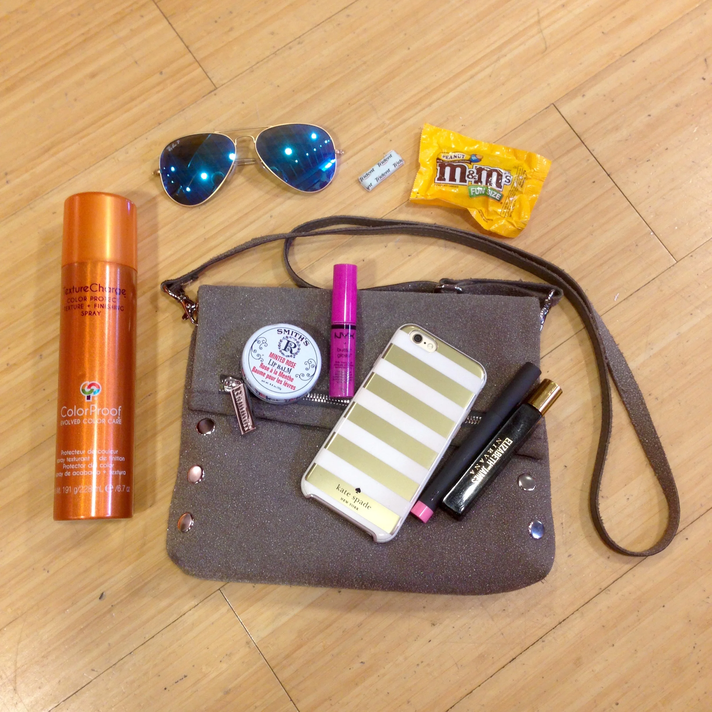 Hammitt Bag Essentials: Color Proof Texture Change finishing spray | Rosebud Perfume Co. Minted Rose lip balm | NYX Butter Gloss | iphone | BITE lipstick | Elizabeth & James Nirvana Black fragrance | Ray Ban Aviator sunnies | Peanut M&Ms | Tident gum