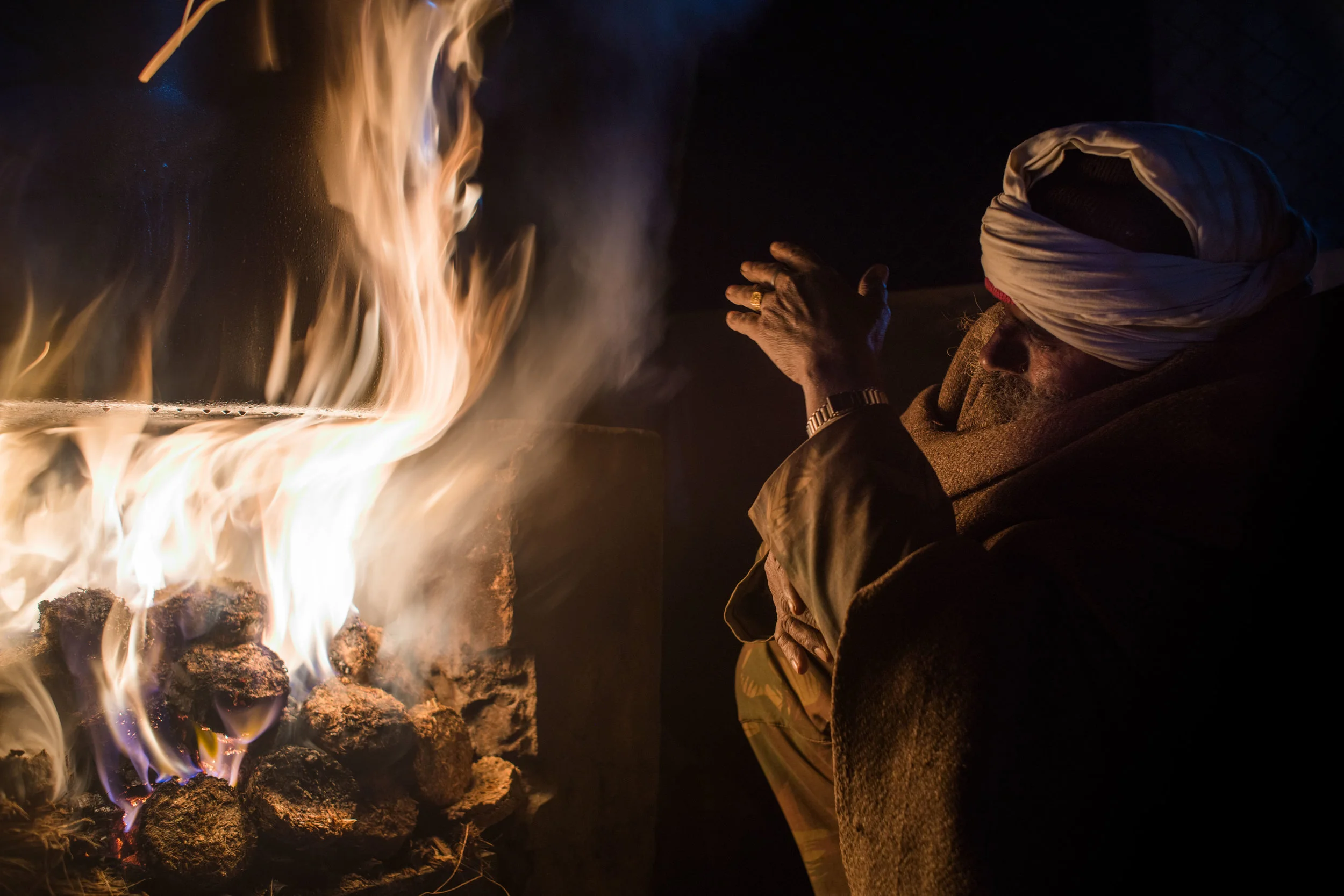 4 am. Manohar lights the fire to cook the porridge for the elephants.