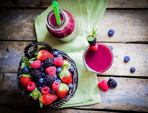 Juice next to blended smoothie with fresh fruit