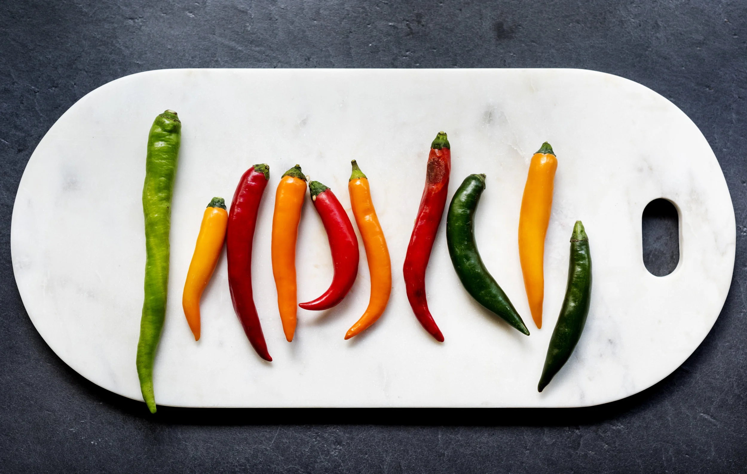 aerial-view-of-cayenne-chili-peppers-on-cutboard-PJC7RKD.jpg