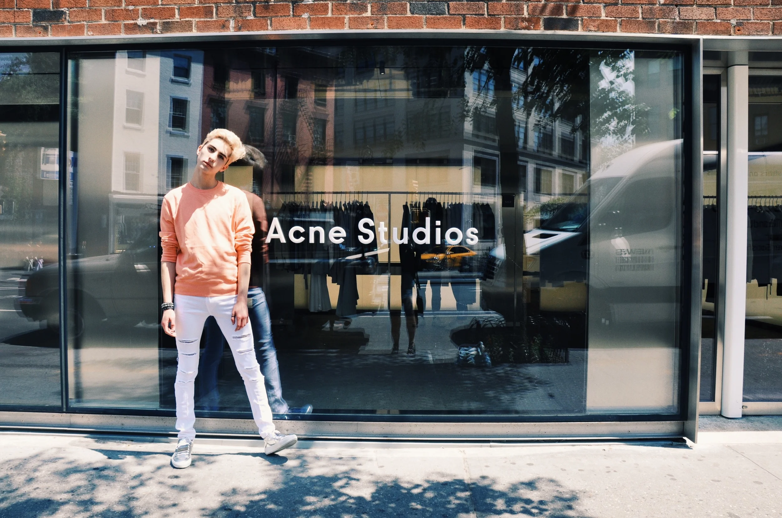 Pictured Above : Ryan Matthew wearing an Acne Studios Coral Melange sweatshirt, H&M white ripped jeans, and Acne Studios Adrian Metal Silver sneakers.