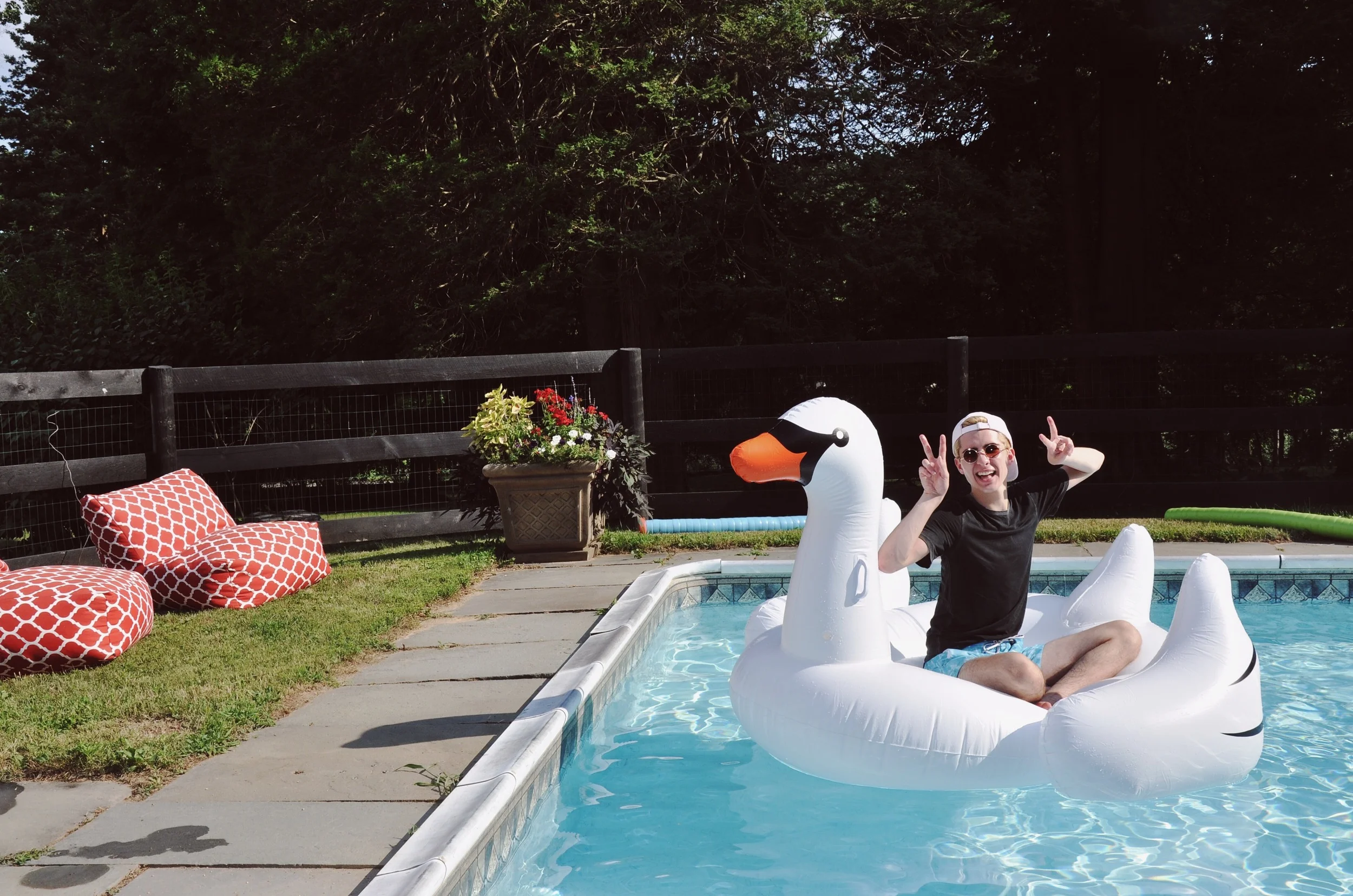Pictured Above : Giant inflatable swan, Cotton Citizen t-shirt, Armani Exchange swimsuit, OBEY pink baseball cap, round vintage sunglasses