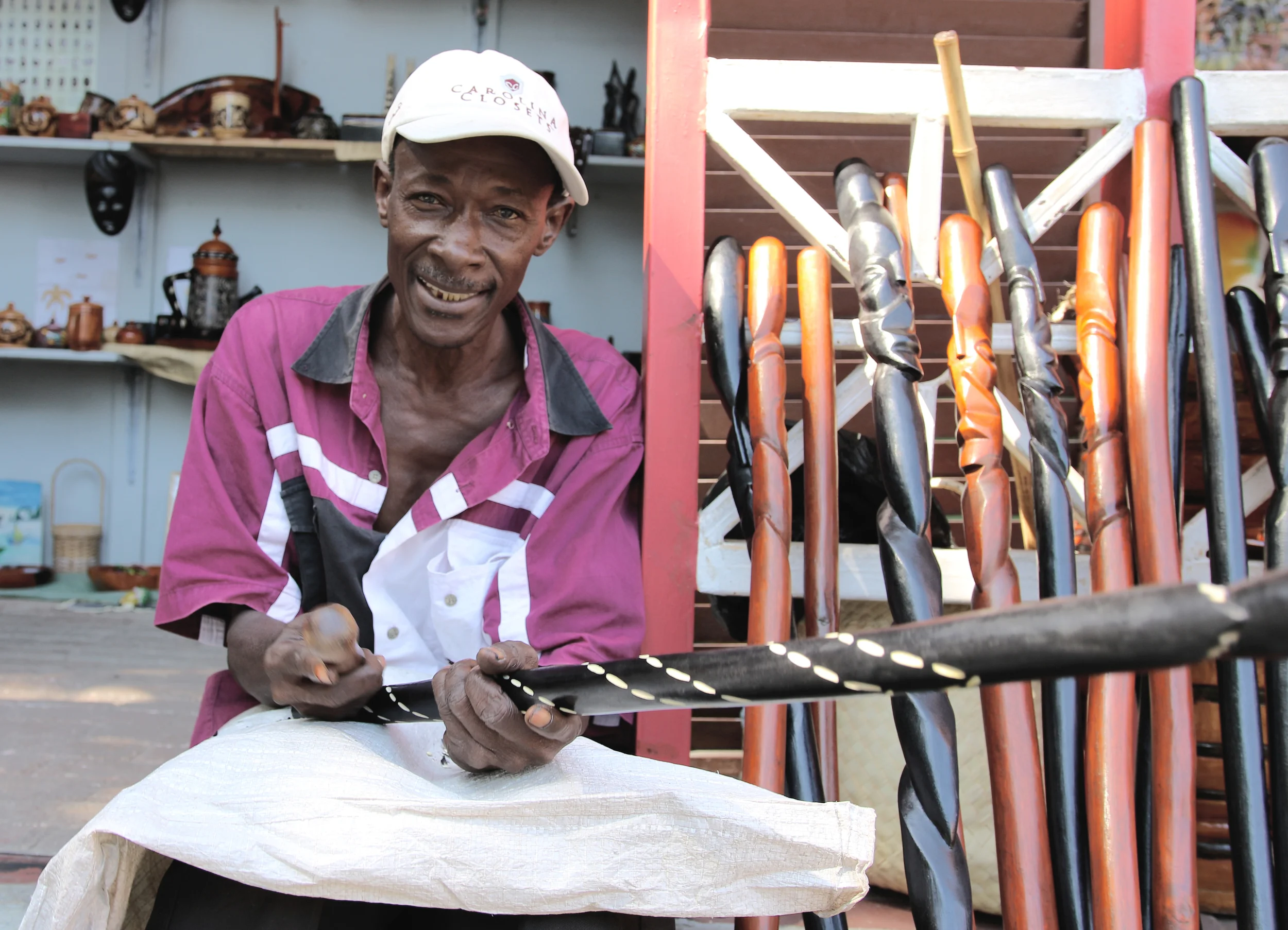 AN ARTISAN CARVES WOOD AND SELLS HIS WORK IN PORT-AU-PRINCE. 