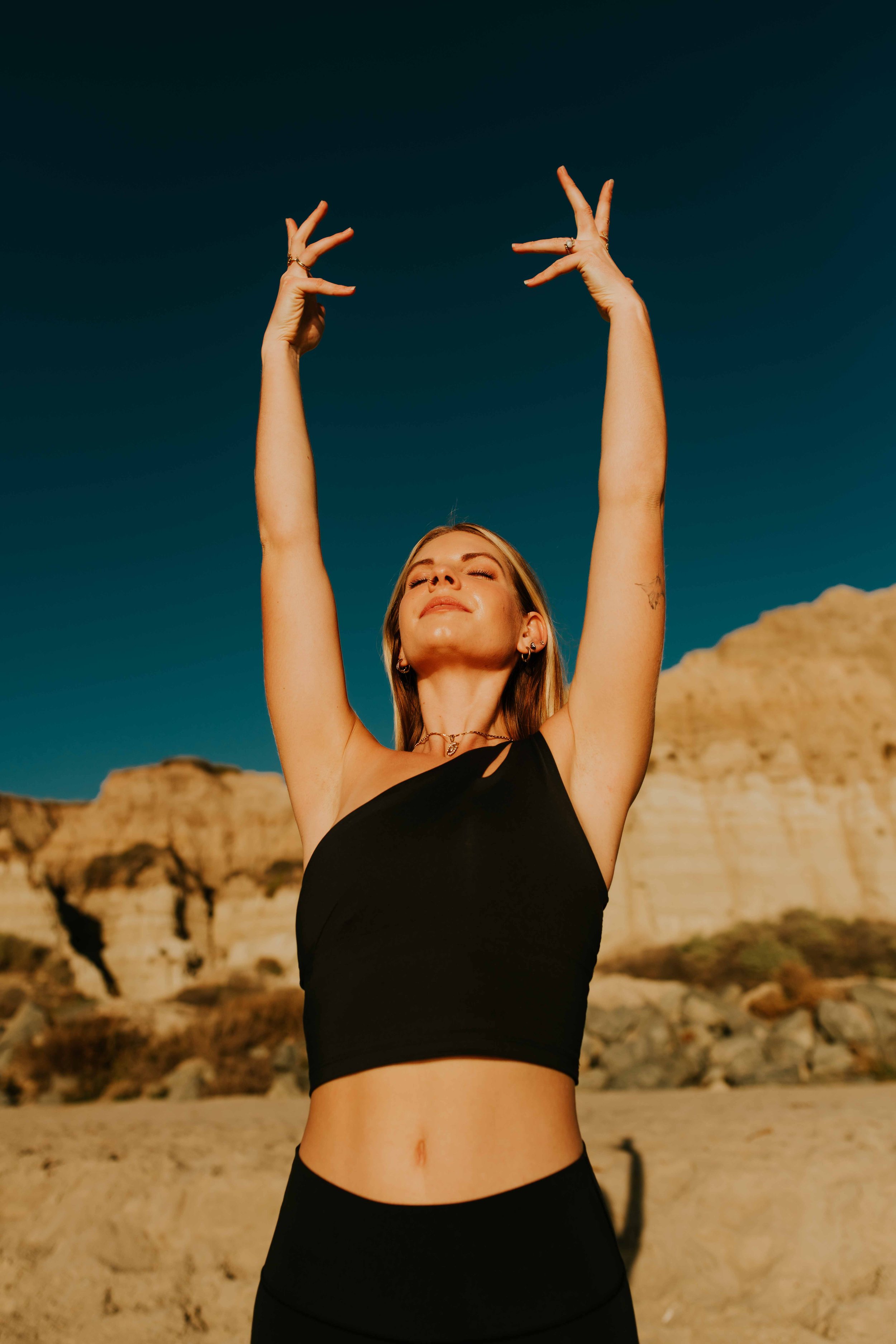  Young women practice yoga poses on San Clemente State Beach for a photoshoot 