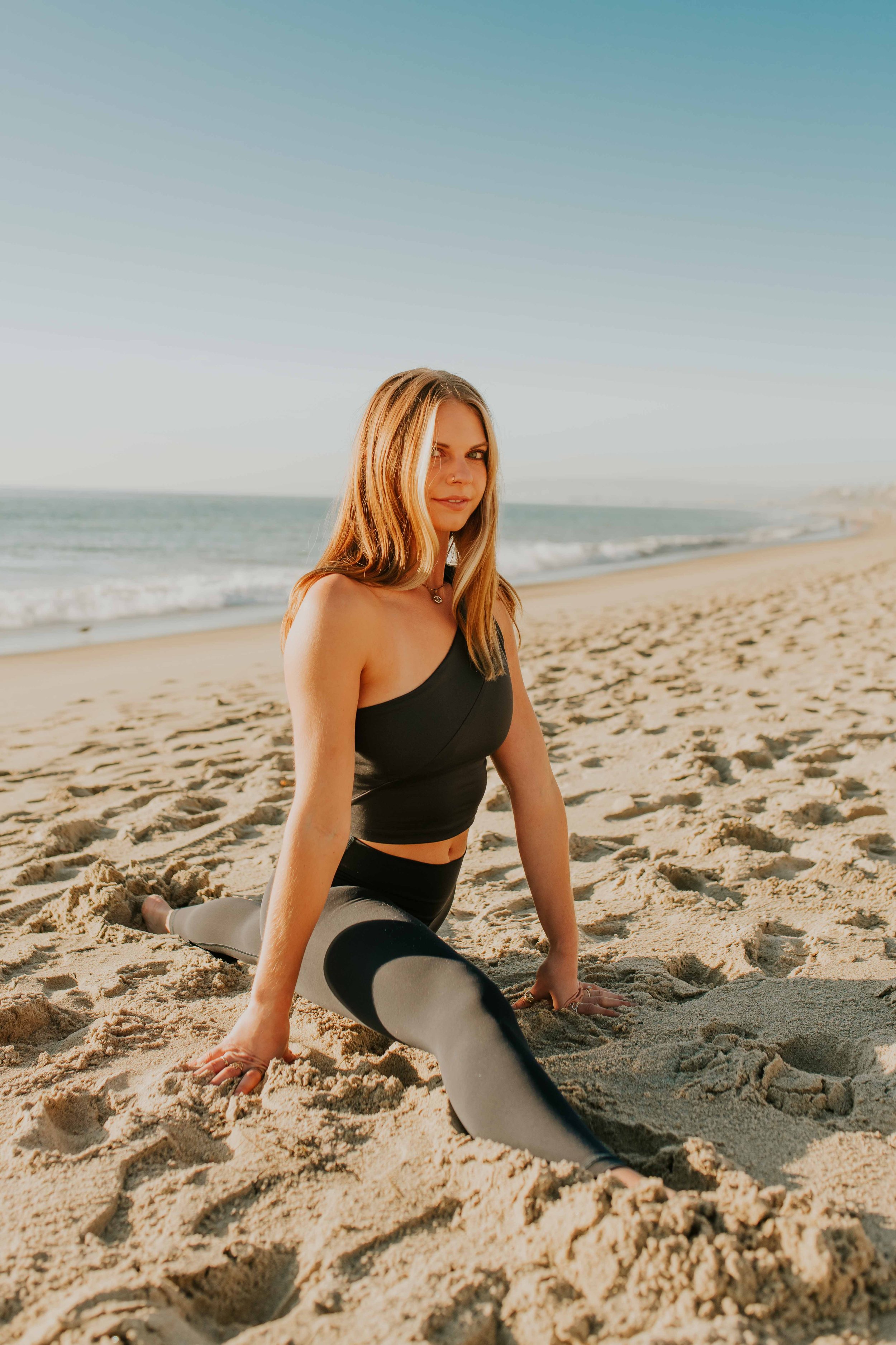 Young women practice yoga poses on San Clemente State Beach for a photoshoot 