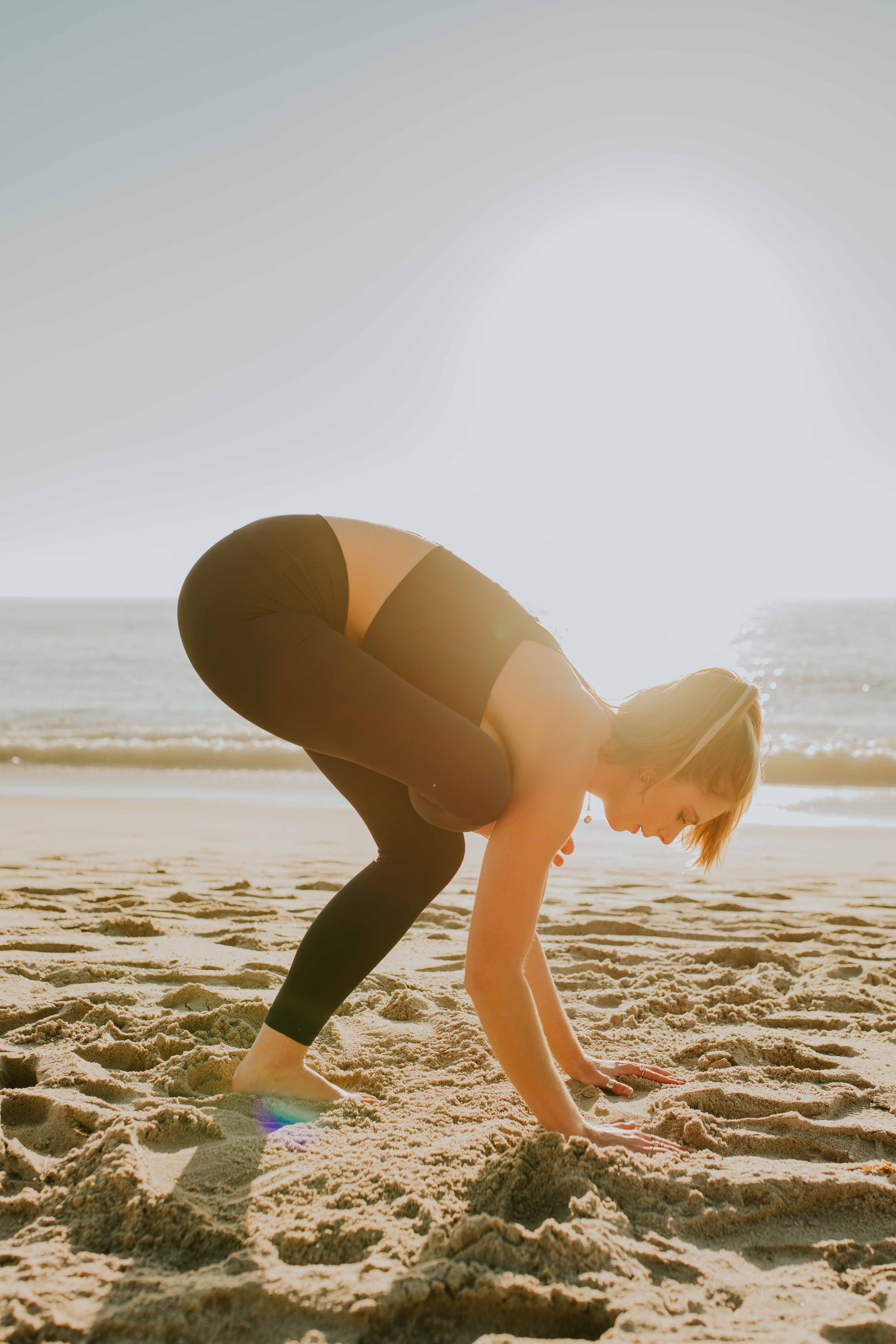  Young women practice yoga poses on San Clemente State Beach for a photoshoot 