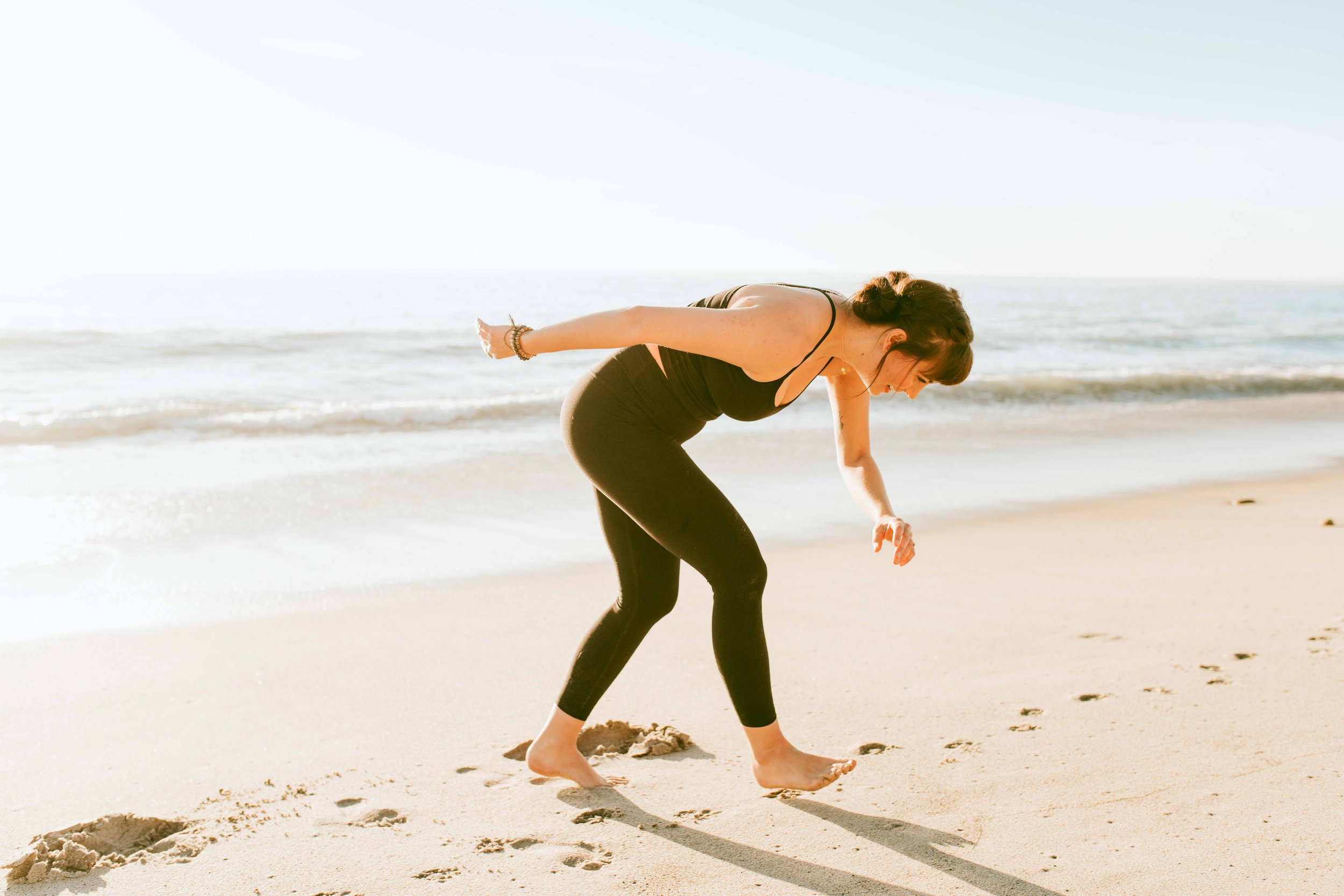  Young women practice yoga poses on San Clemente State Beach for a photoshoot 