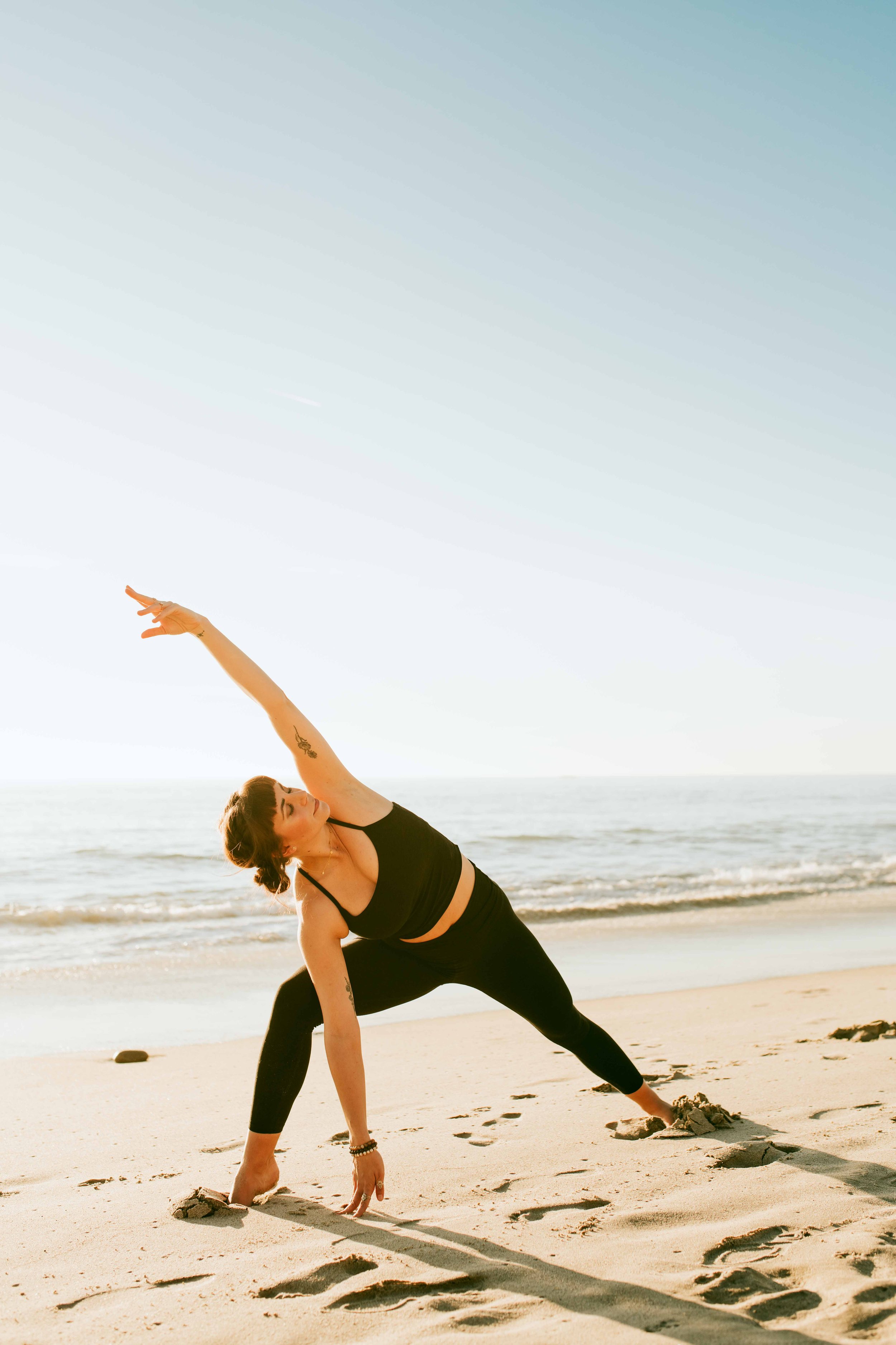  Young women practice yoga poses on San Clemente State Beach for a photoshoot 