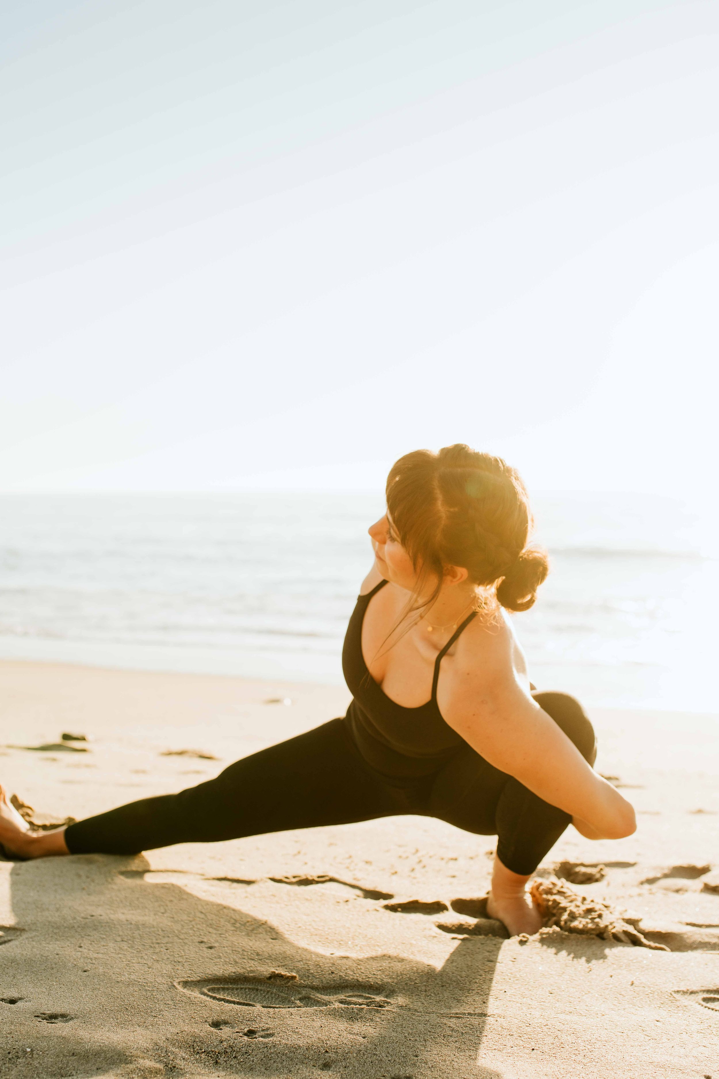  Young women practice yoga poses on San Clemente State Beach for a photoshoot 