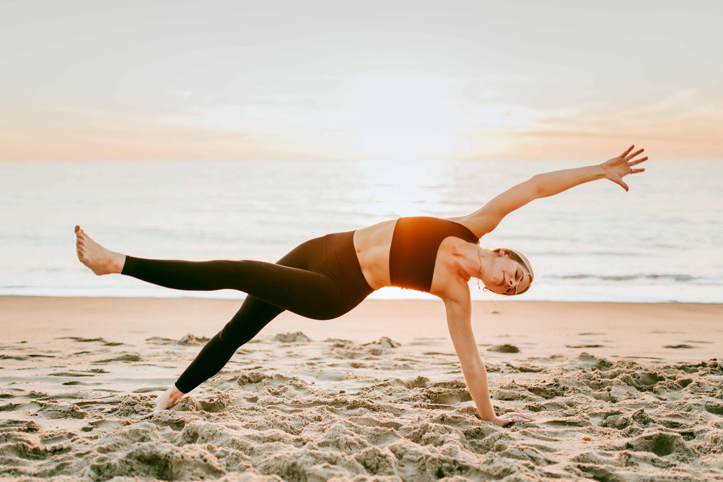  Young women practice yoga poses on San Clemente State Beach for a photoshoot 