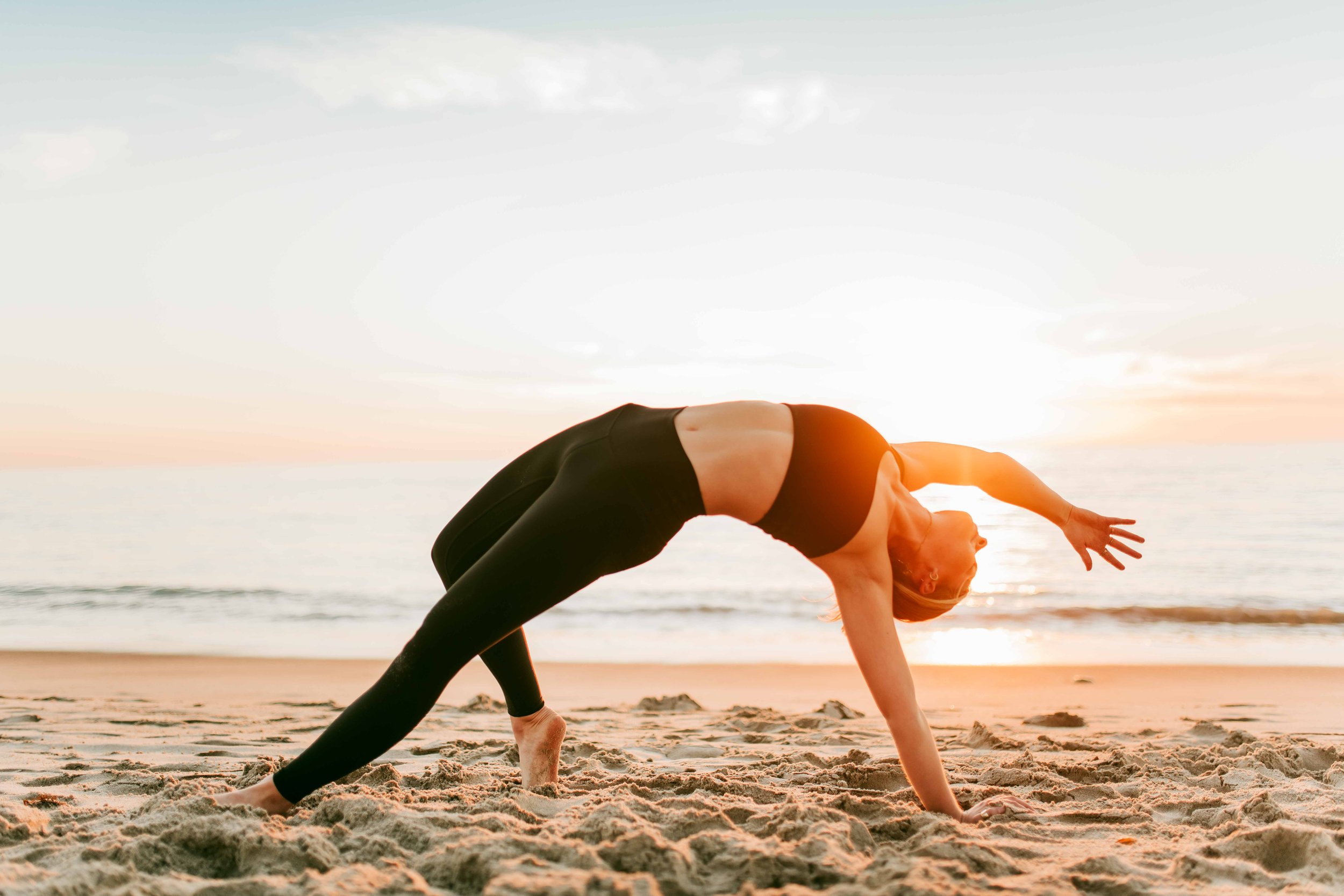  Young women practice yoga poses on San Clemente State Beach for a photoshoot 