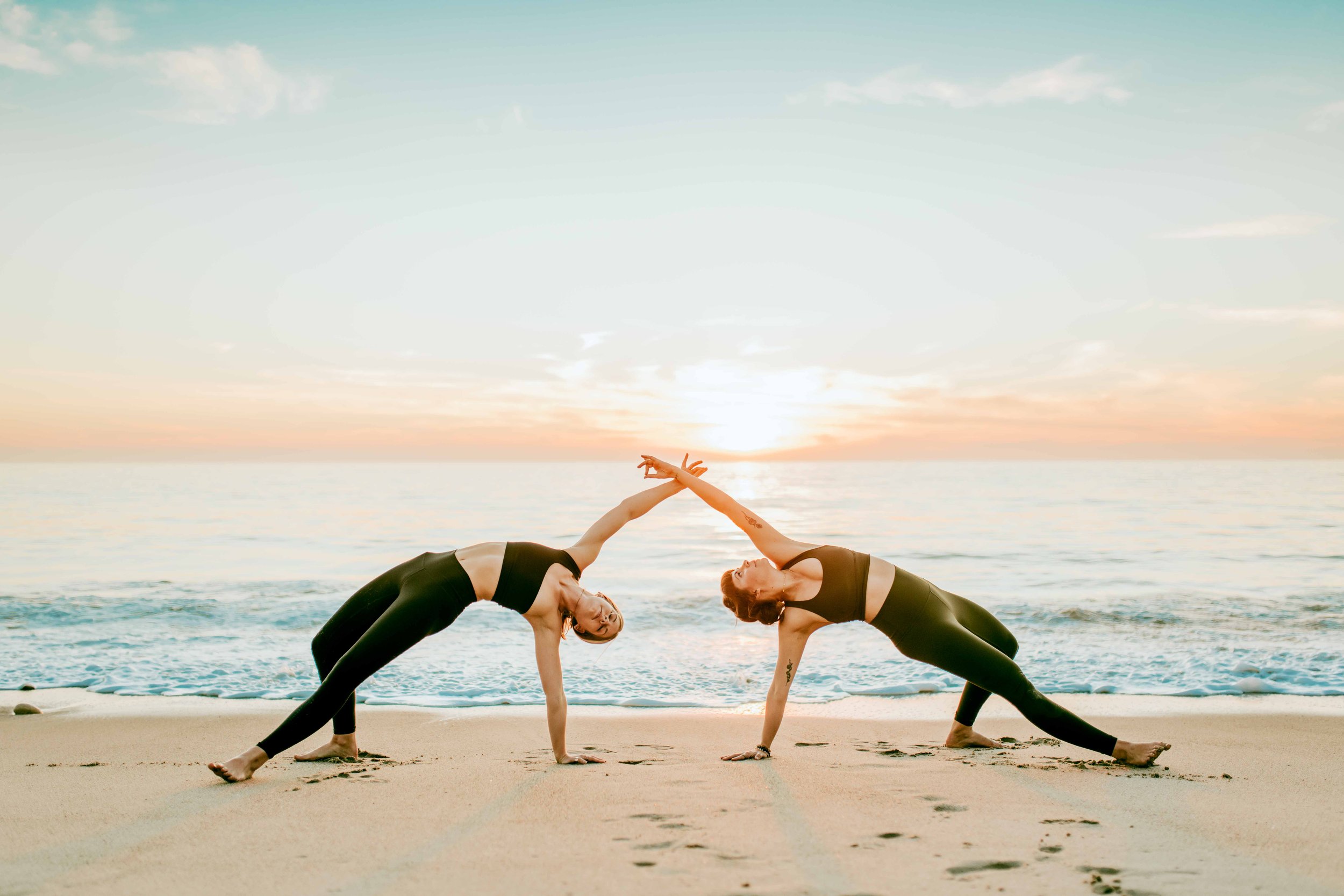  Young women practice yoga poses on San Clemente State Beach for a photoshoot 