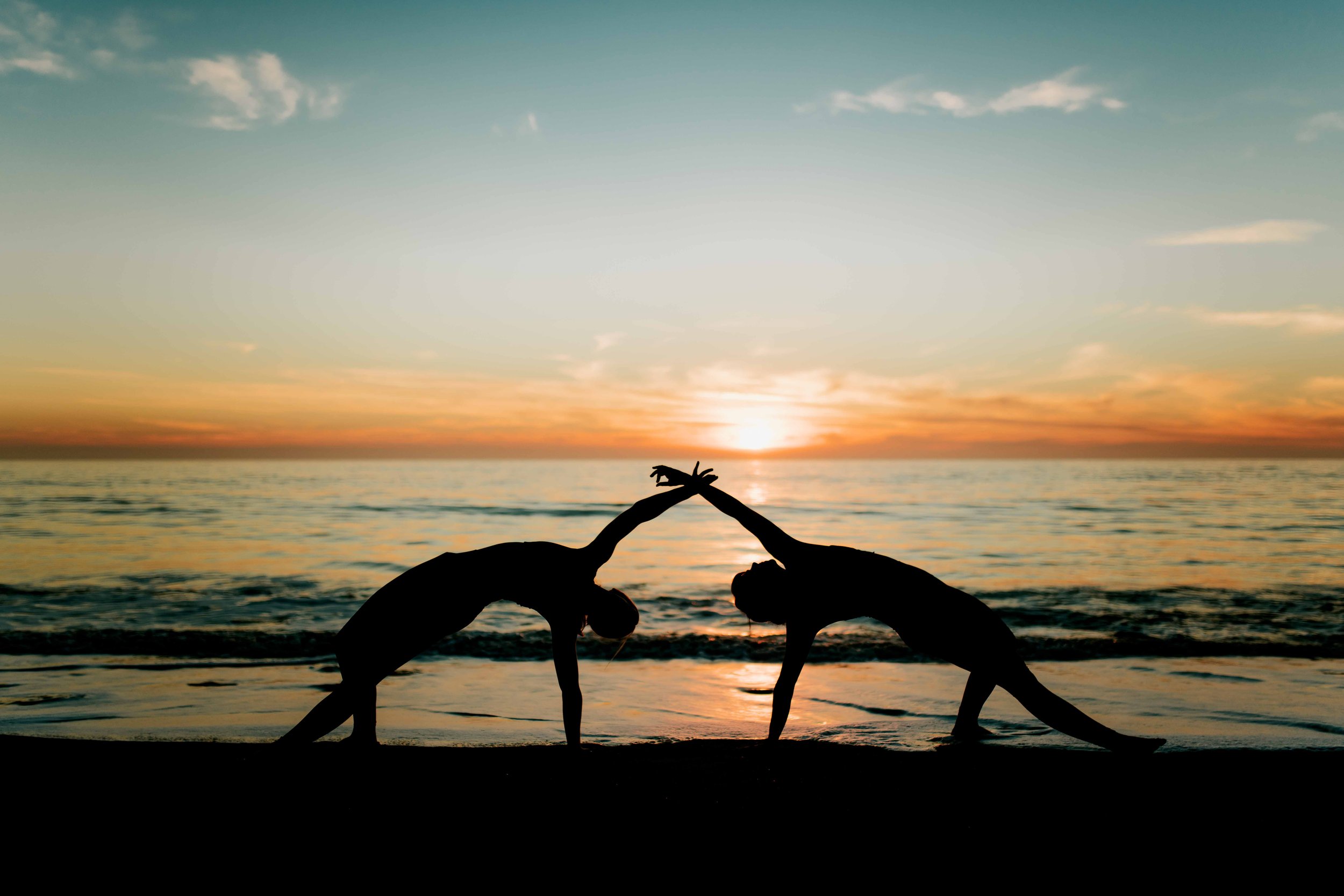  Young women practice yoga poses on San Clemente State Beach for a photoshoot 