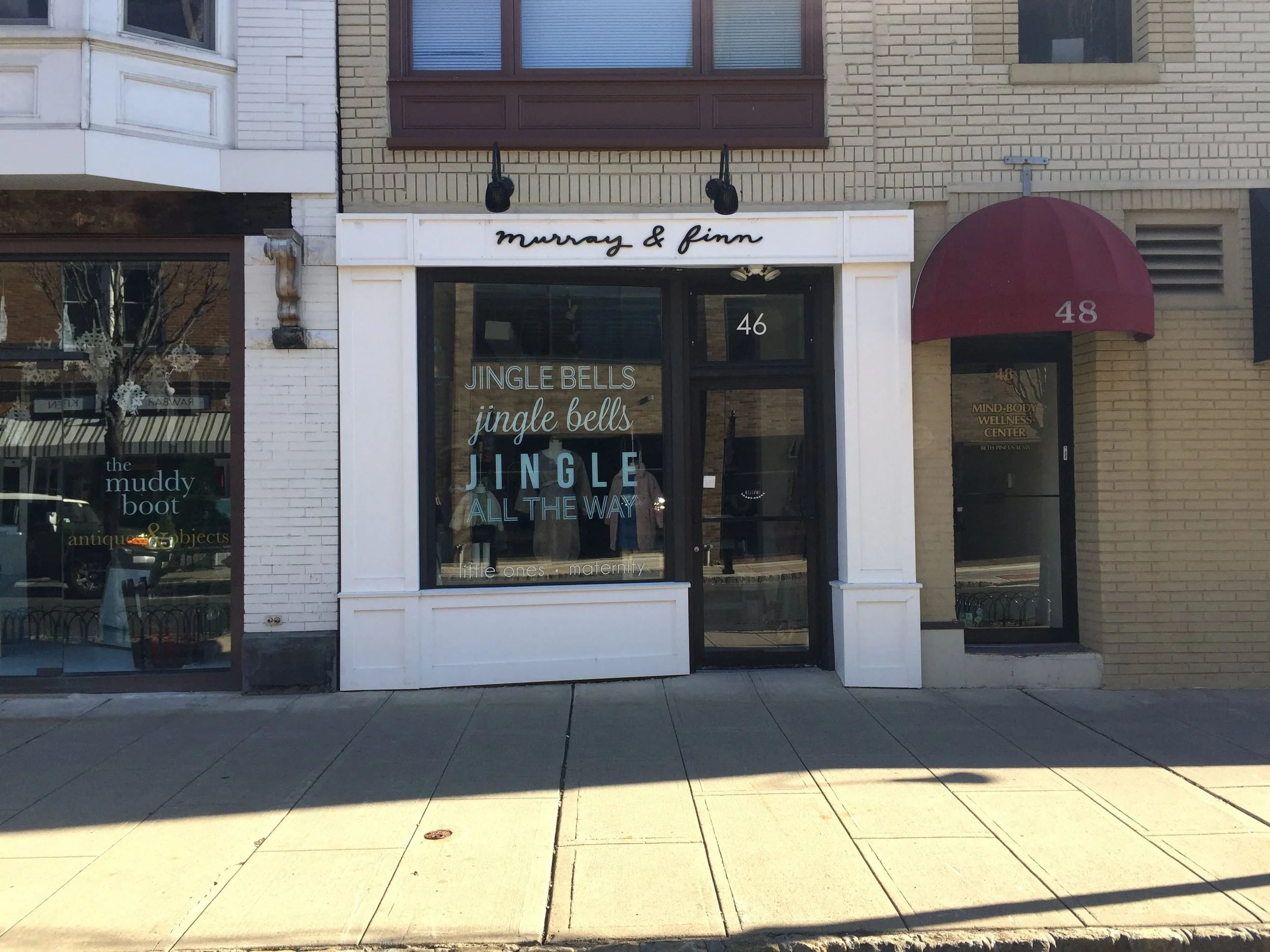 Murray & Finn, Summit uses adhesive lettering instead of solid signage that blocks the storefront window. This is especially important for stores such as this one that has a small display window area.