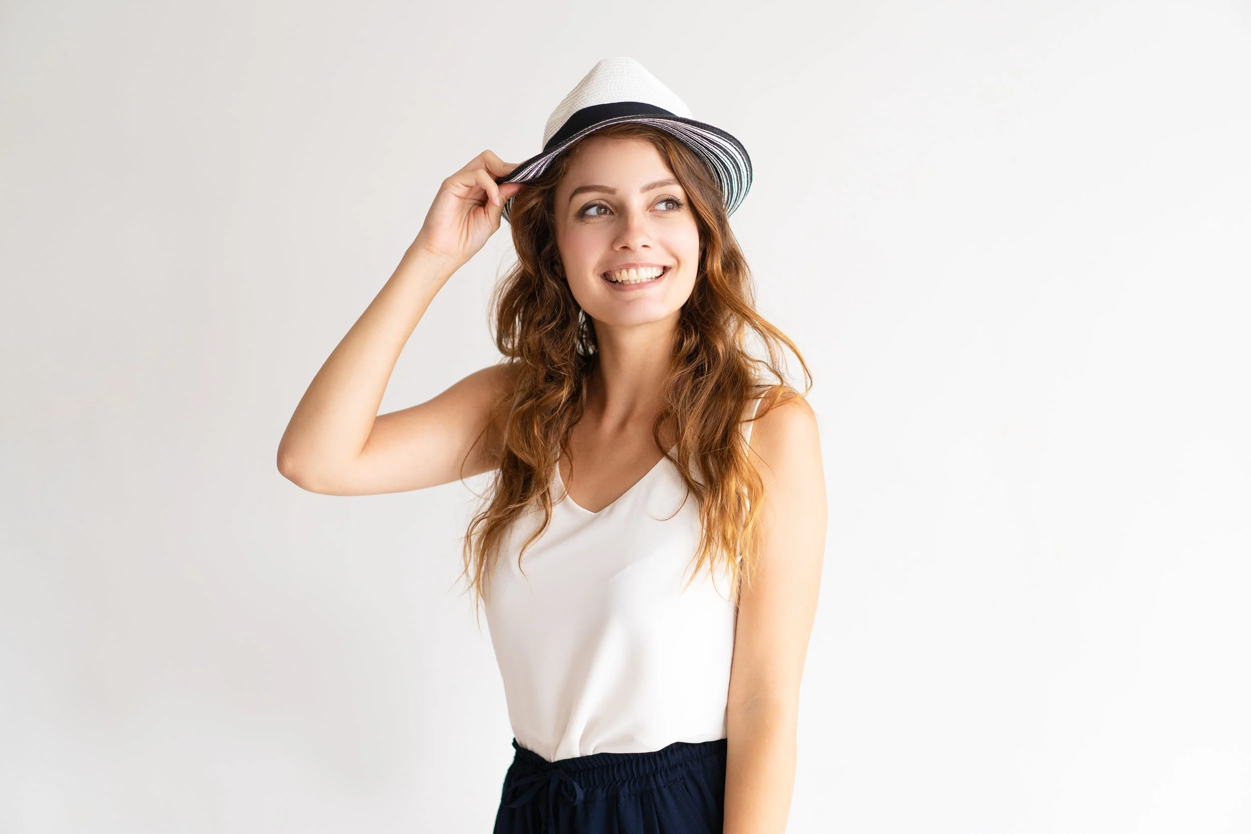 Portrait of happy stylish young woman posing in hat