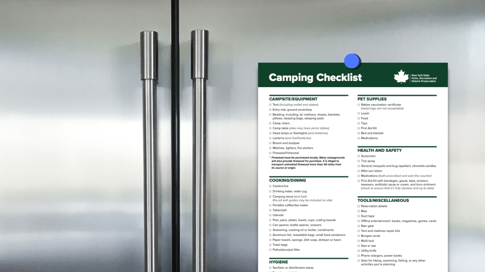 A camping checklist posted on a silver refrigerator door with metal handles.