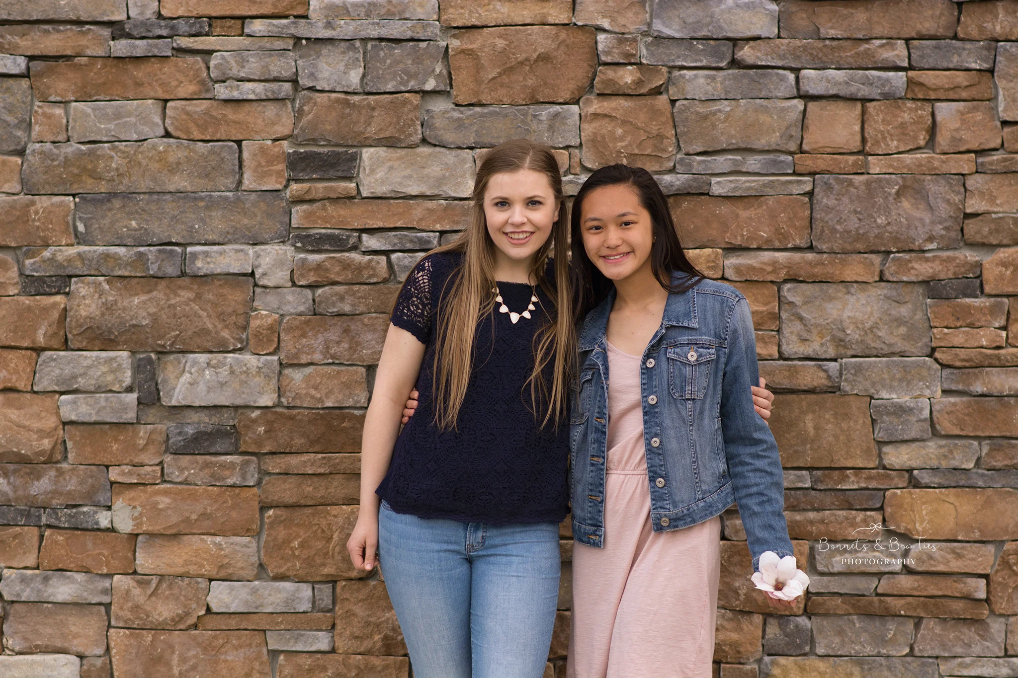 teen girls posing against rock wall.jpg