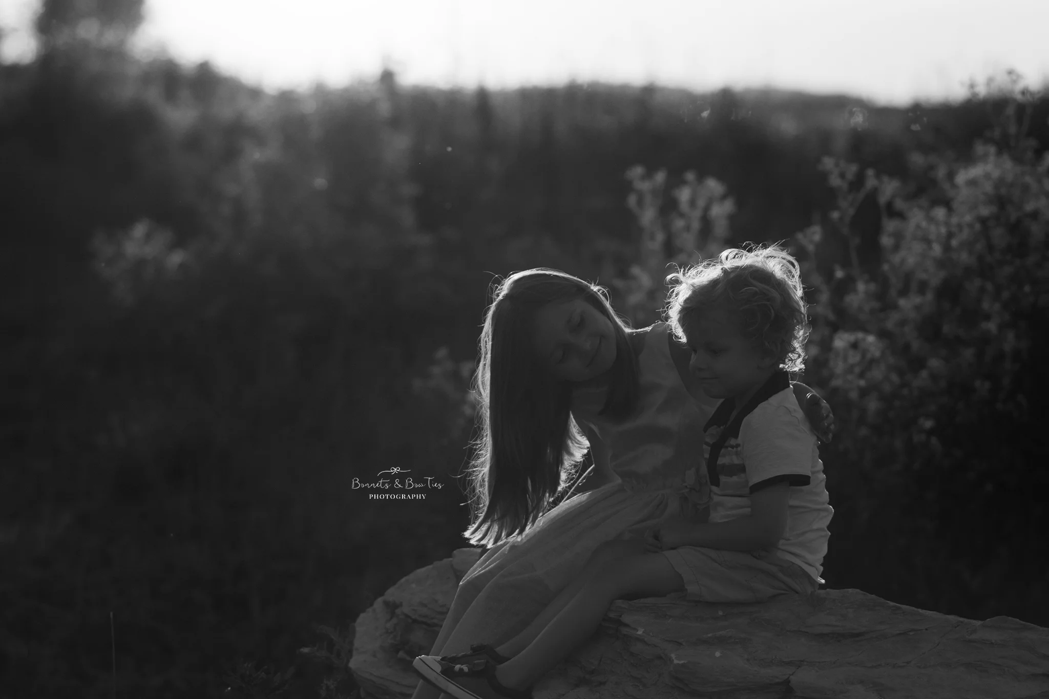 black and white of two kids sitting on a rock.jpg