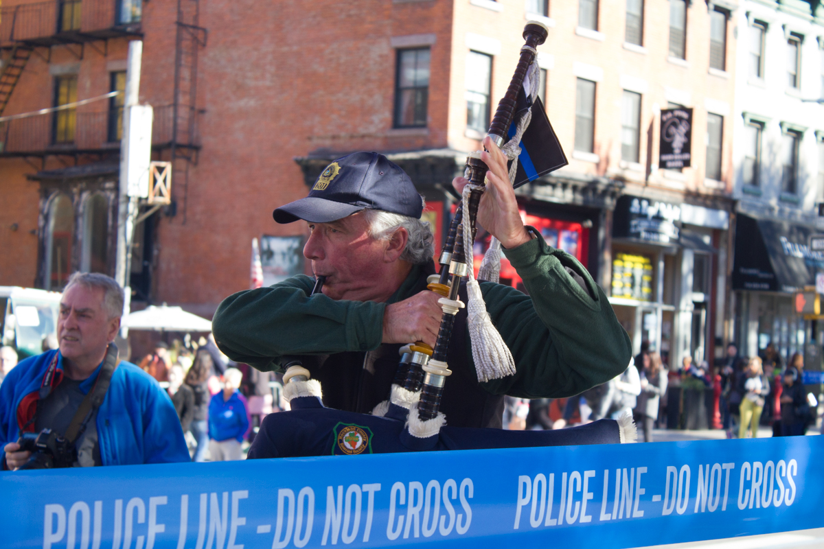 A man plays the bagpipes for marathoners and spectators alike in Brooklyn.