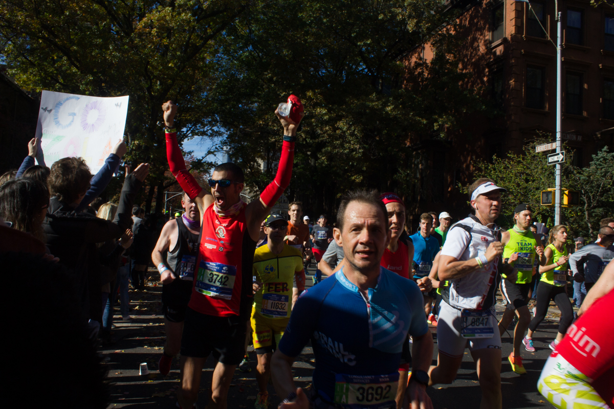 A marathoner cheers back at the crowd.