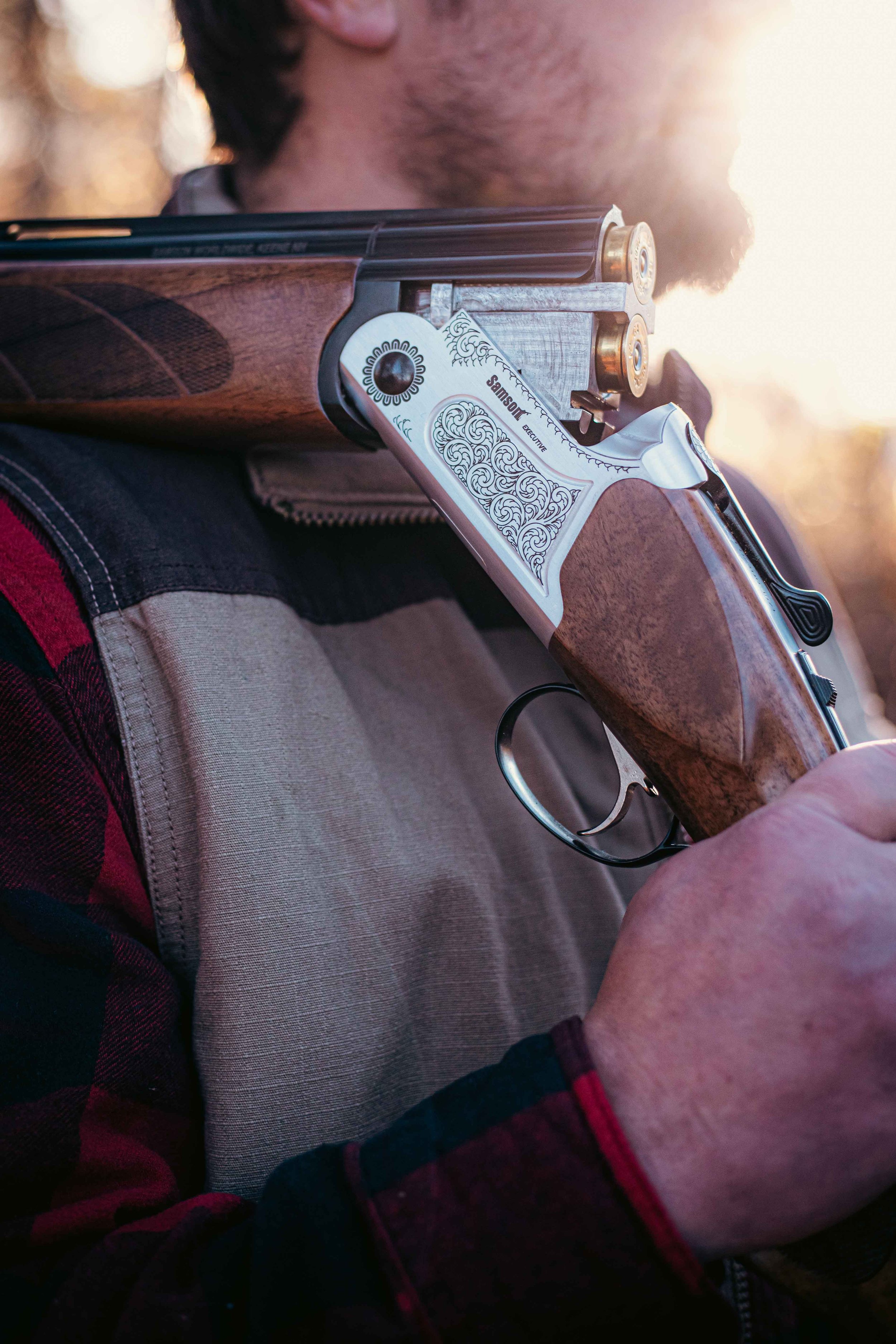 Person holding a shotgun over shoulder