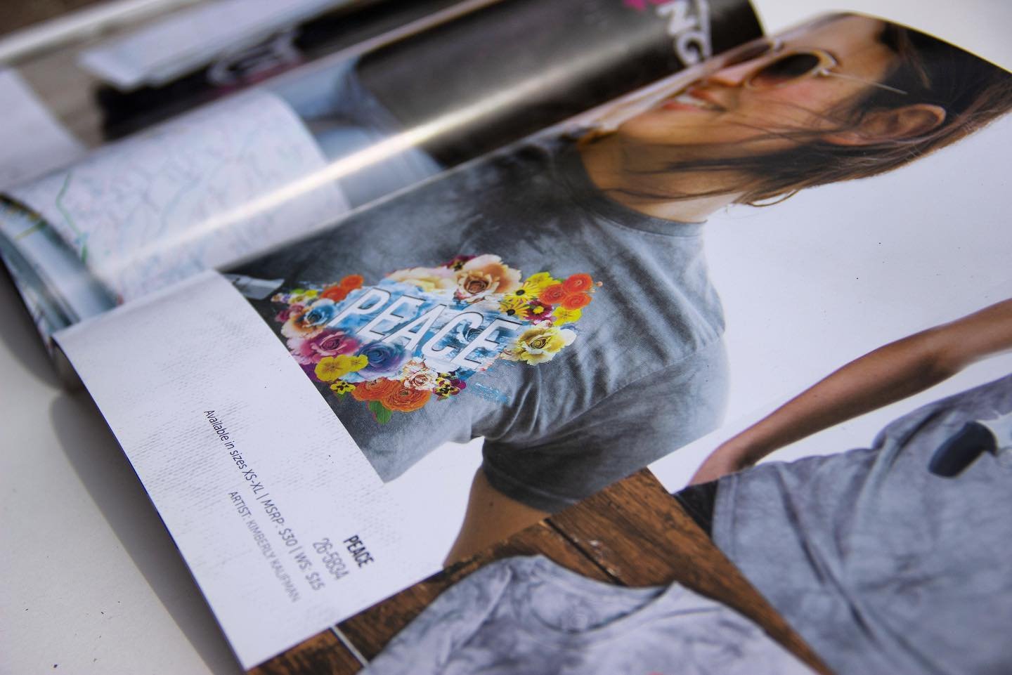 Magazine page featuring a model wearing a T-shirt with 'PEACE' and floral design.