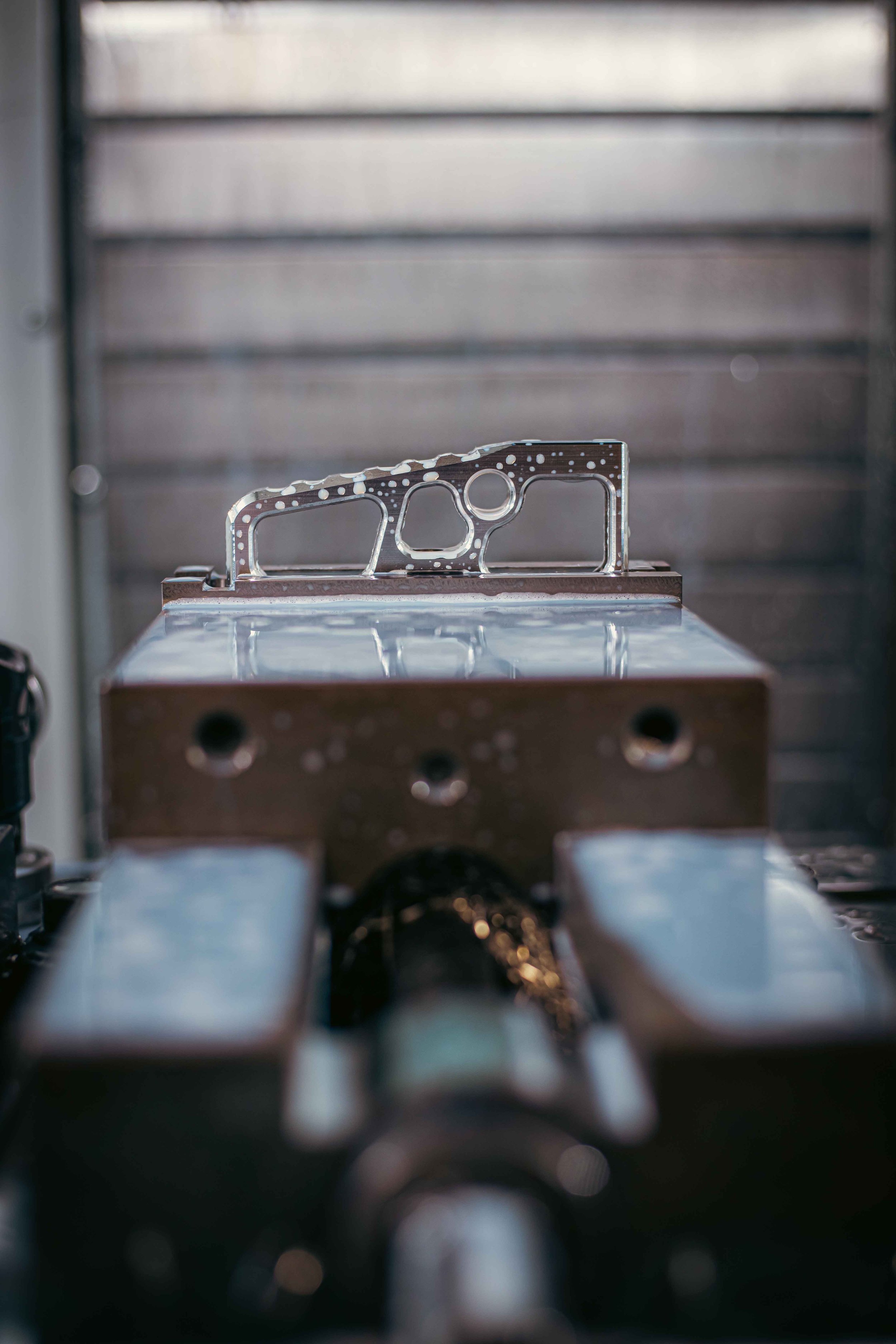 Close-up of a precision-machined metal component on a milling machine in a workshop.